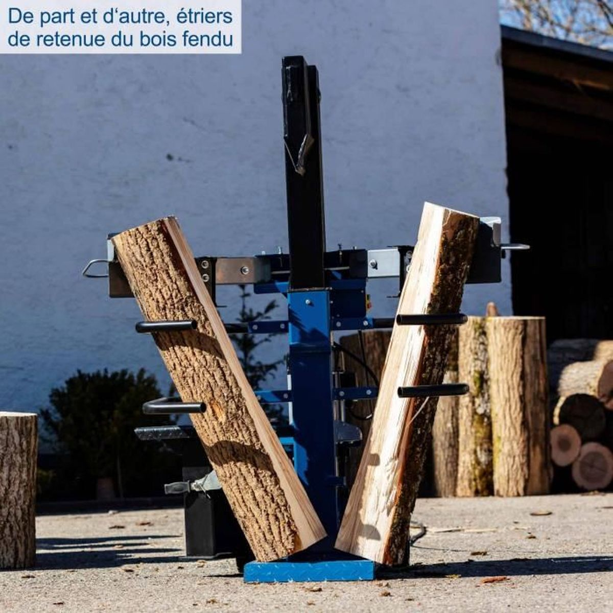 Ein Holzspalter mit zwei Holzstämmen. Im Hintergrund sind weitere geschnittene Holzstücke zu sehen.