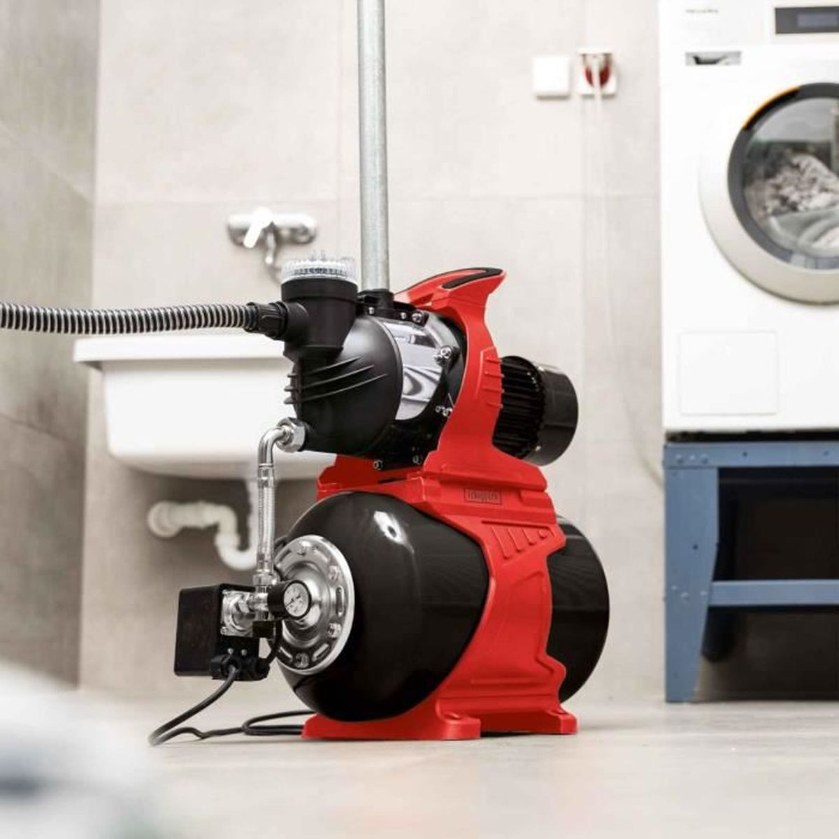 Rote und schwarze Wasserpumpe. Im Hintergrund eine Waschmaschine.
