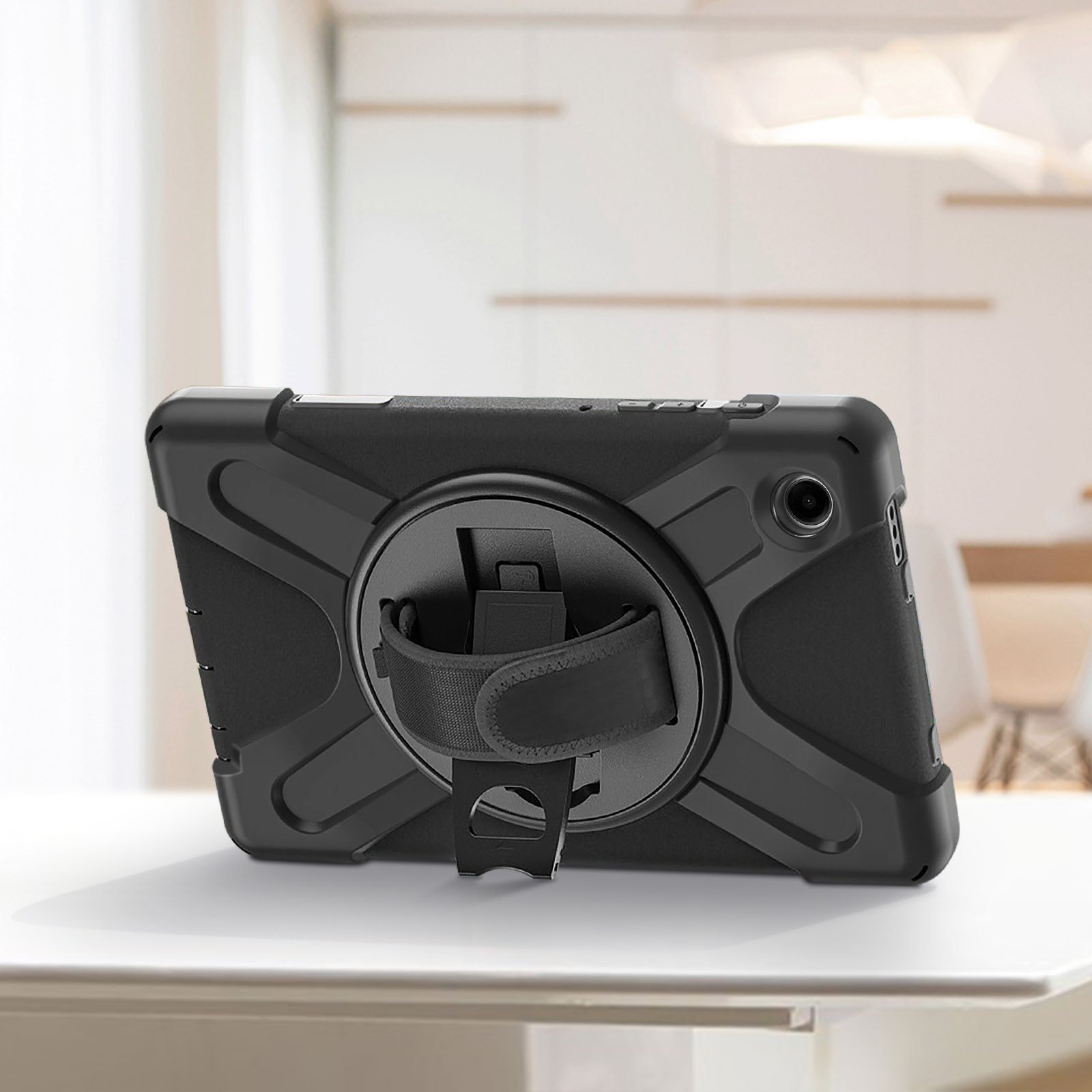 Ein schwarzes Tablet mit Schutzhülle und einem drehbaren Handriemen auf weißer Oberfläche.