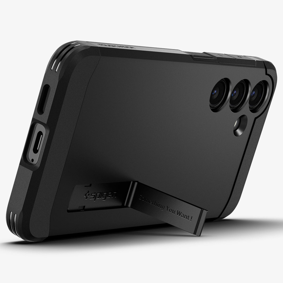 Téléphone noir dans un étui avec béquille indiquant 'Something You Want!' et le logo Spigen.