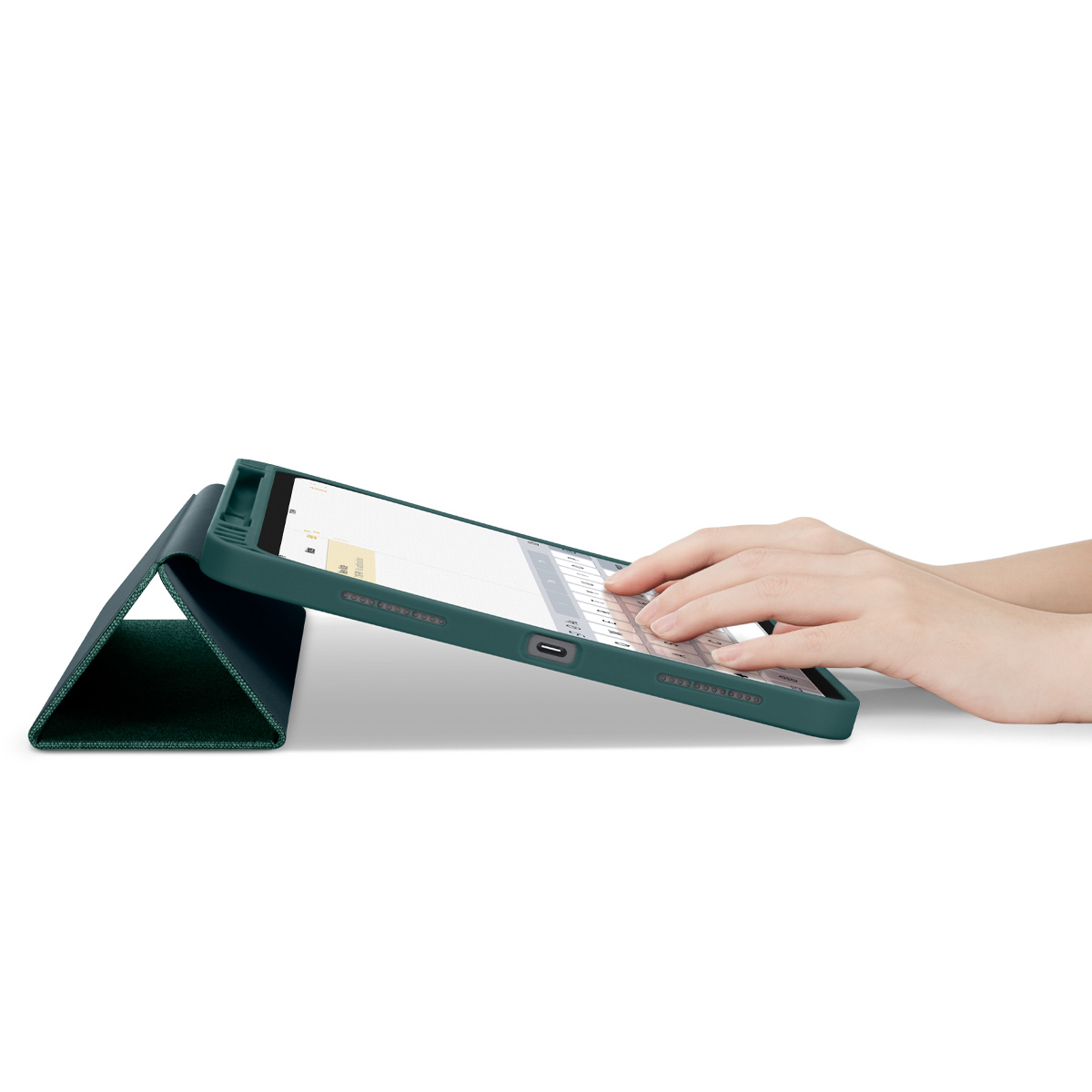 Hands typing on a tablet with a green keyboard case. Tablet is on a stand.