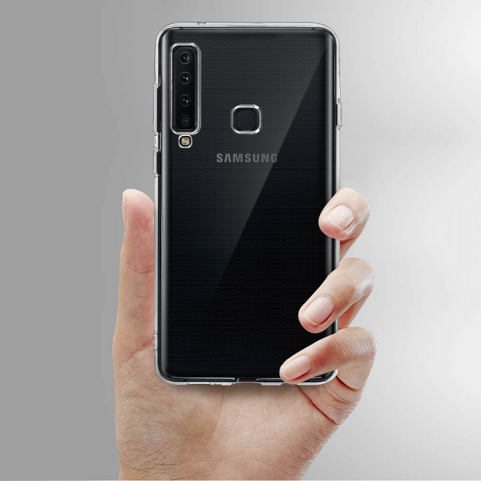 Una mano che tiene un telefono Samsung nero con una custodia trasparente. Il telefono ha più fotocamere.