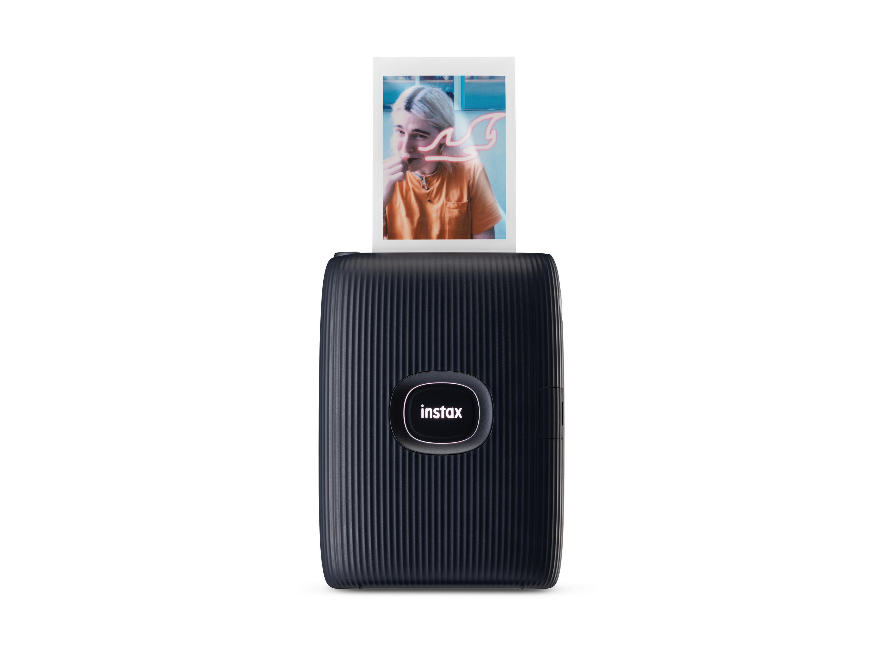 Ein dunkelblauer Instax Mini Link 2 Drucker, der ein Foto einer Person druckt.