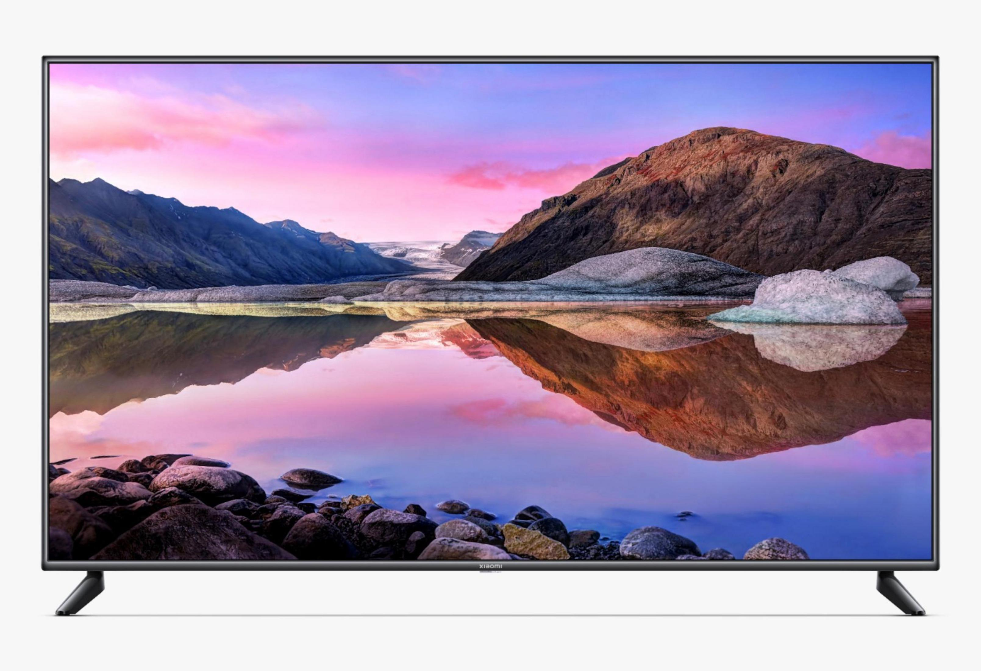 Een grote flatscreen-tv die een meerlandschap toont met bergen en een kleurrijke lucht die in het water wordt weerspiegeld.