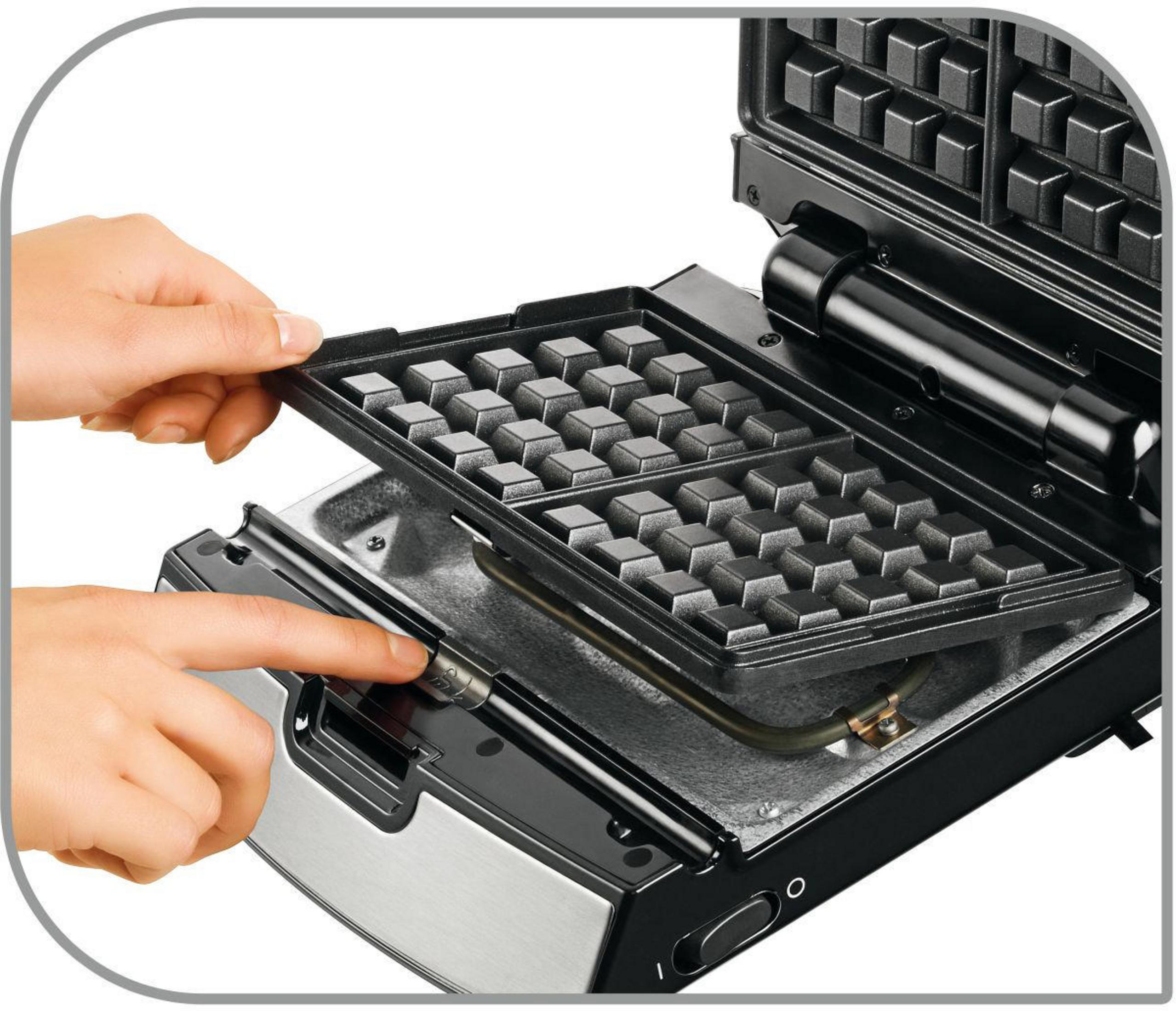 Waffeleisen geöffnet, mit einer Hand, die einen Knopf drückt. Eisen ist schwarz und silber.