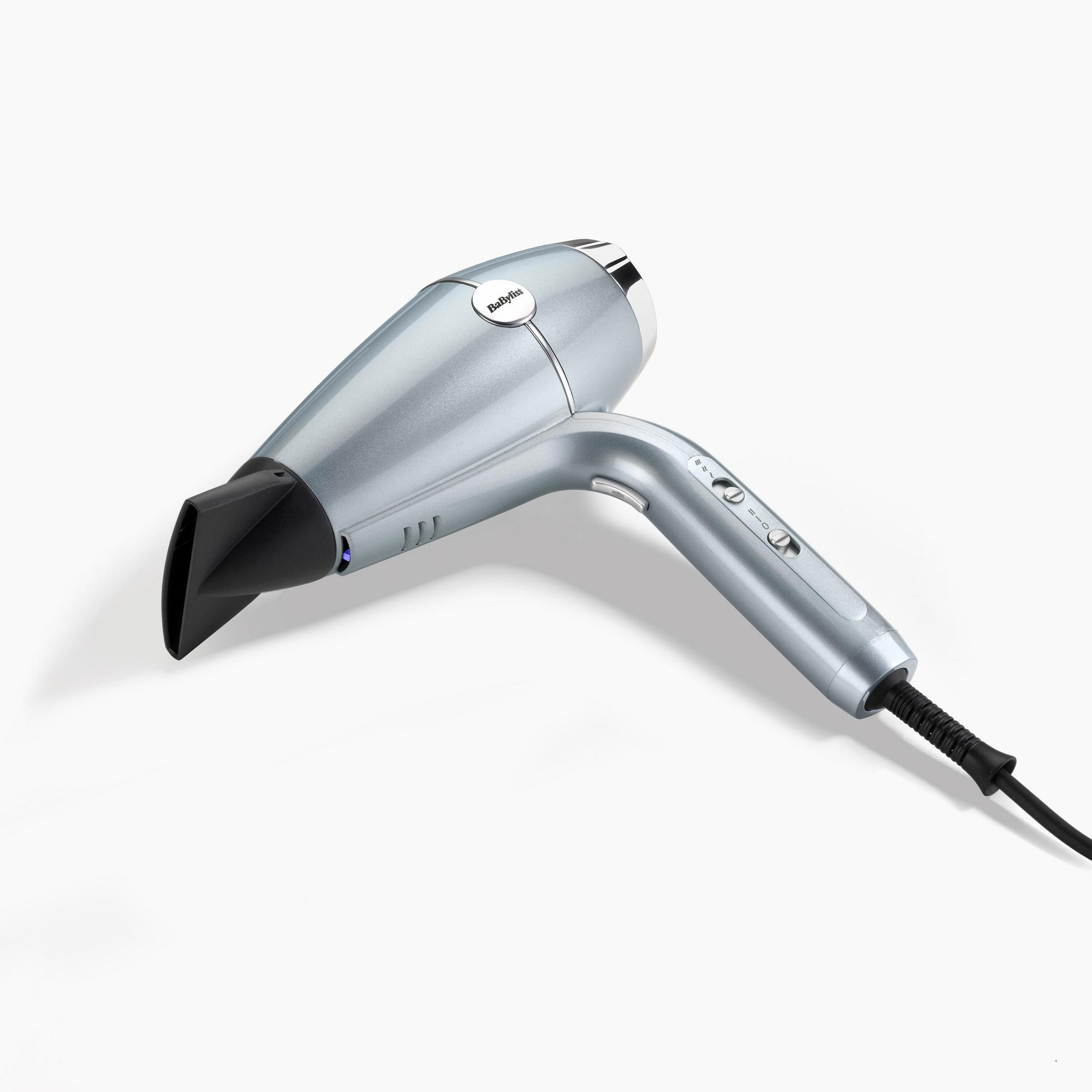 Srebrna suszarka do włosów Babyliss, czarna dysza, białe tło. Ustawienia włączania i wyłączania na uchwycie.