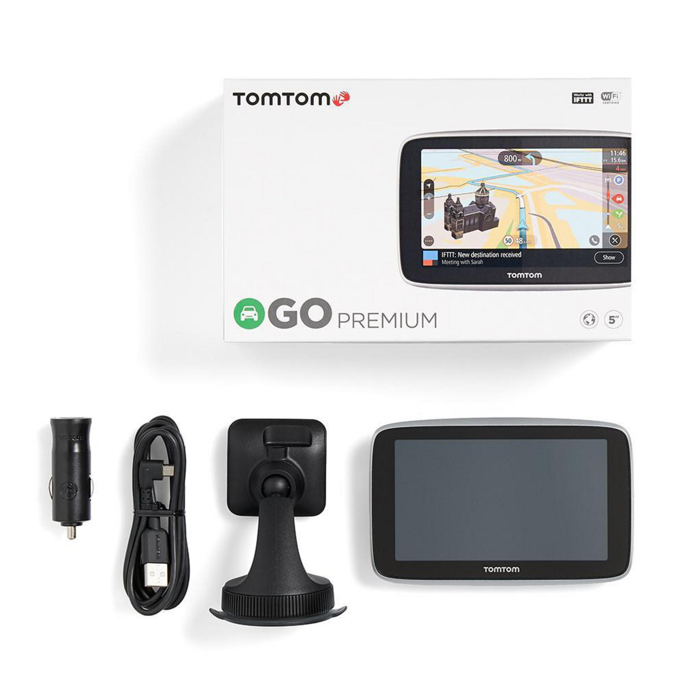 TomTom Go Premium GPS-Gerät und Zubehör: Halterung, Ladegerät, Kabel, im Karton, weißer Hintergrund.