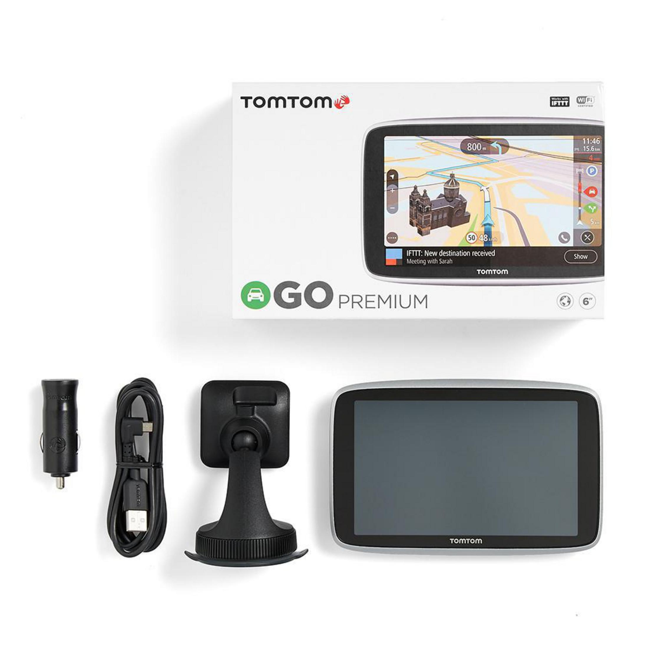Ein GPS-Gerät, ein Autoladegerät, ein Kabel und eine Halterung auf weißem Hintergrund. Das Gerät ist in einer Box.