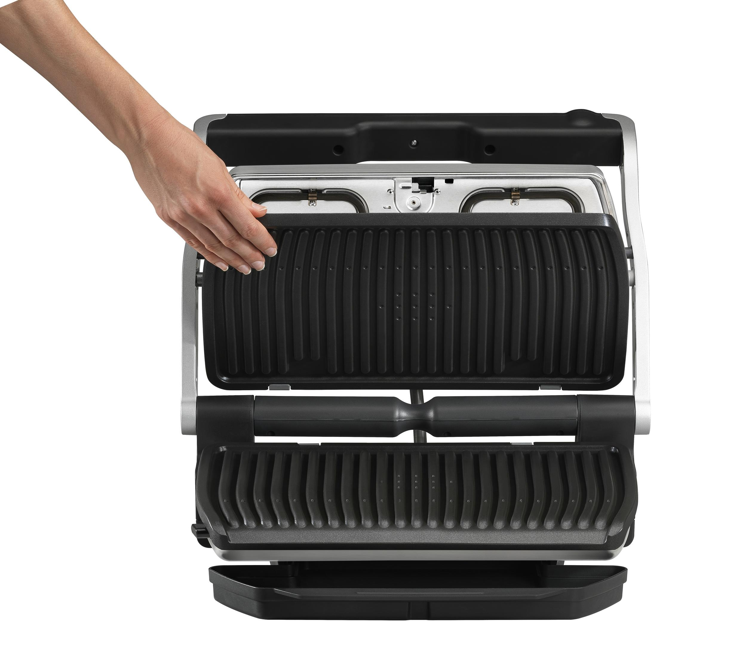 Hand hält den Deckel eines Paninimakers geöffnet, schwarzes und silbernes Gerät.