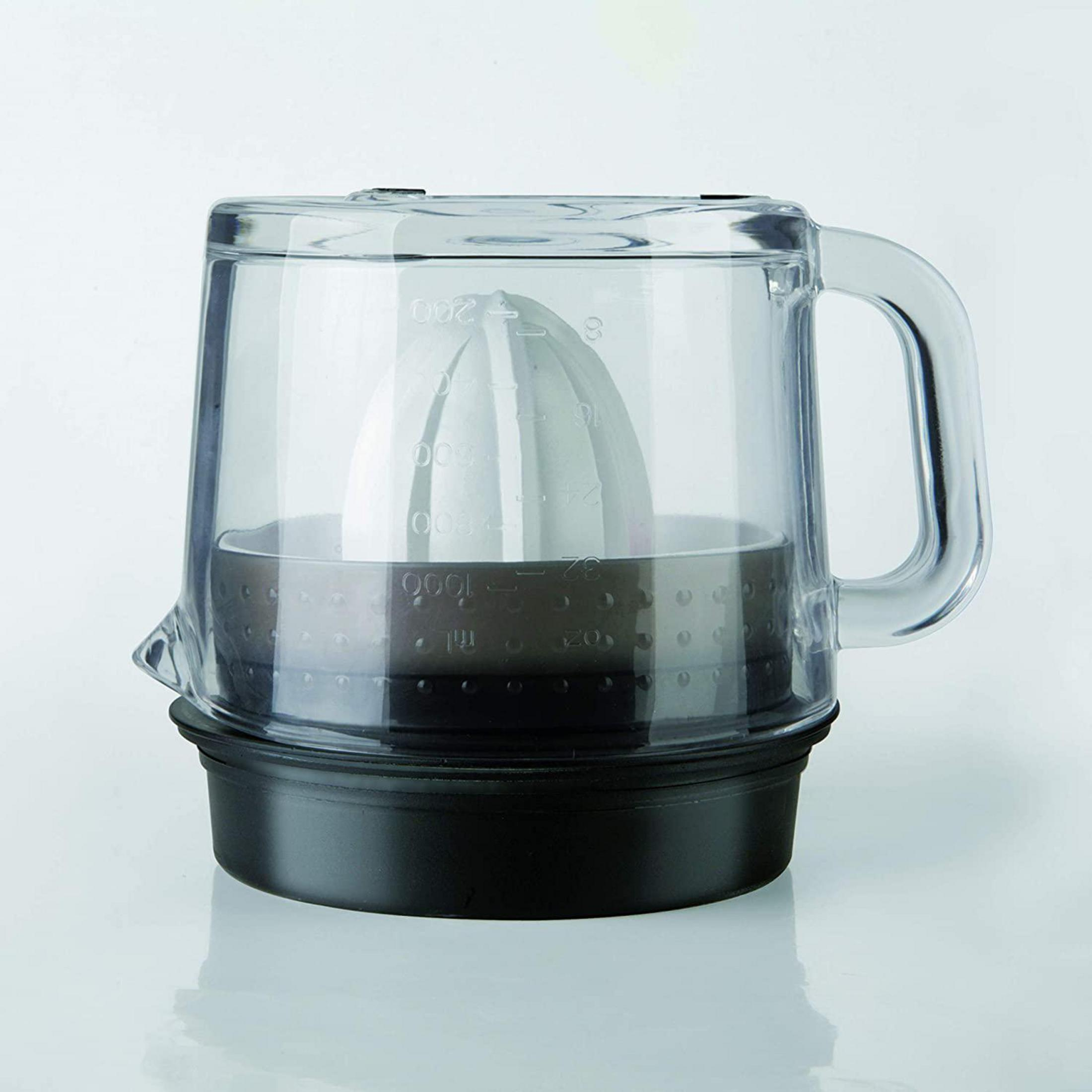 Exprimidor de plástico transparente con cono gris y base negra, sobre superficie blanca.