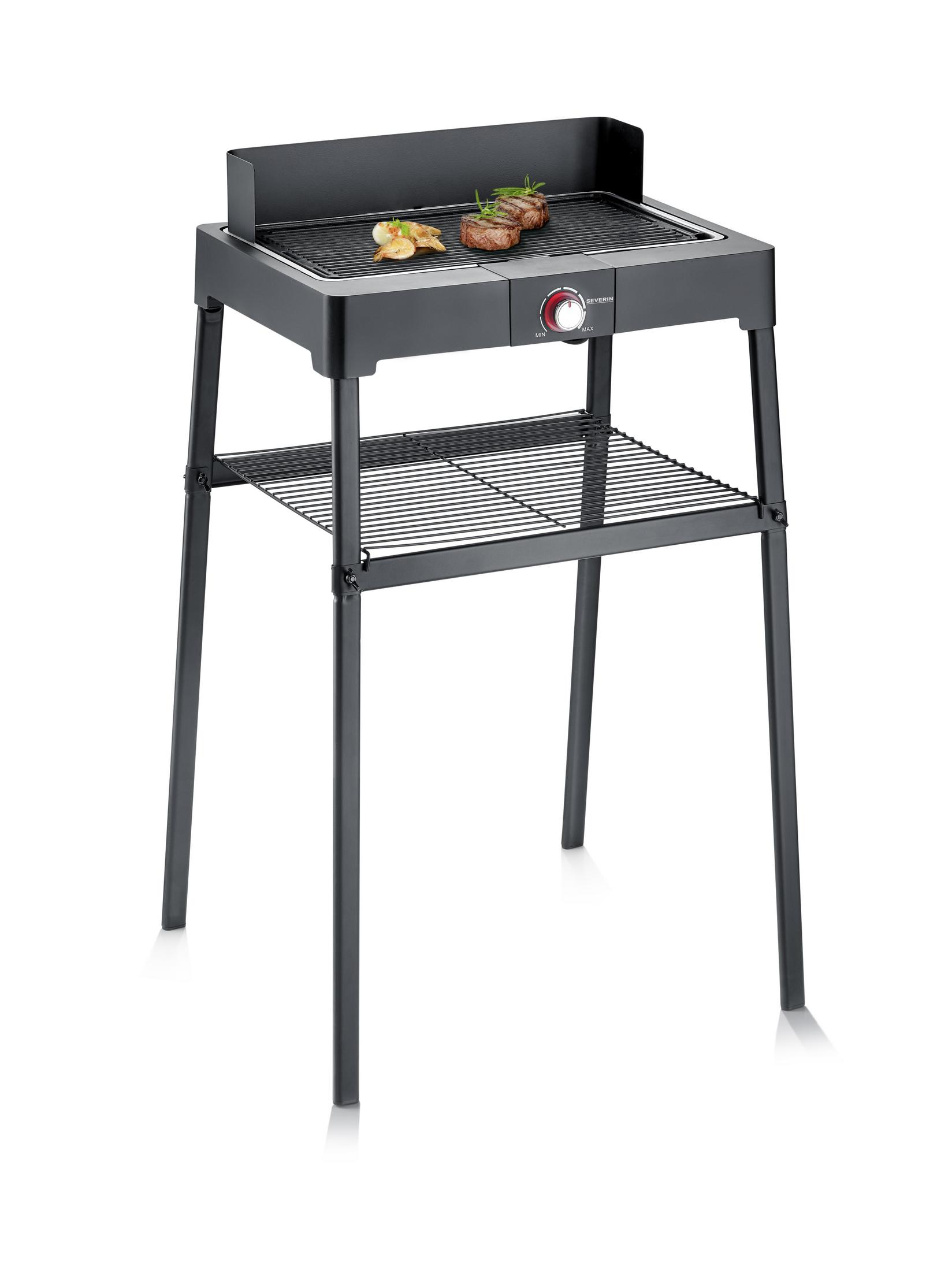 Schwarzer Elektrogrill auf einem Ständer. Zwei Steaks und eine Zitronenscheibe auf dem Grill. Weißer Hintergrund.