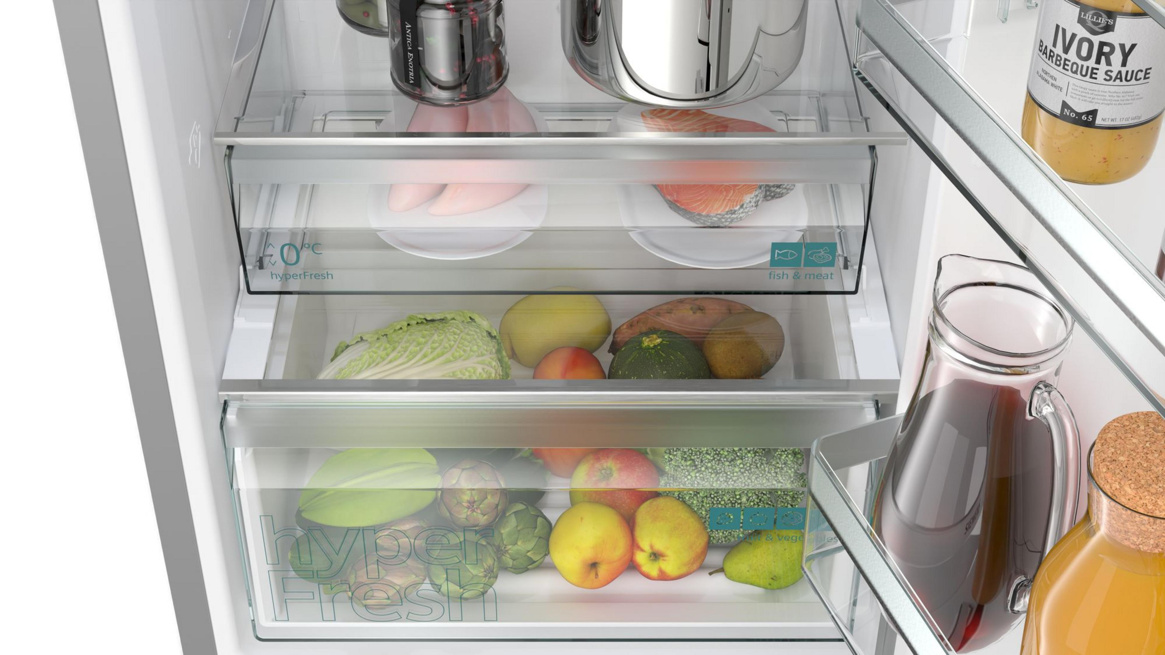 Dentro de un refrigerador con estantes de comida: pescado, verduras y salsa.