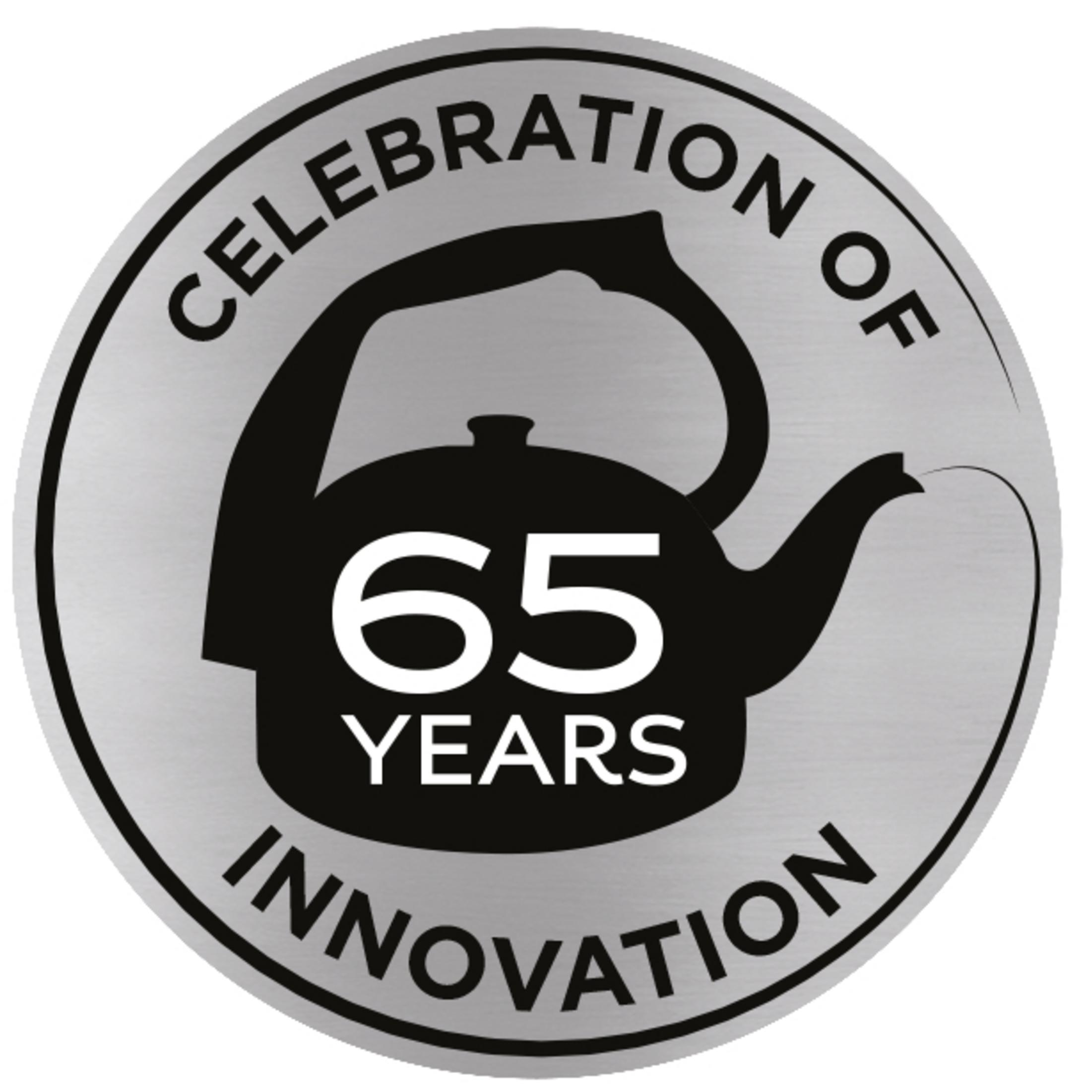 Ein silbernes Abzeichen mit einer schwarzen Kessel-Illustration und dem Text „65 Jahre Innovation“.