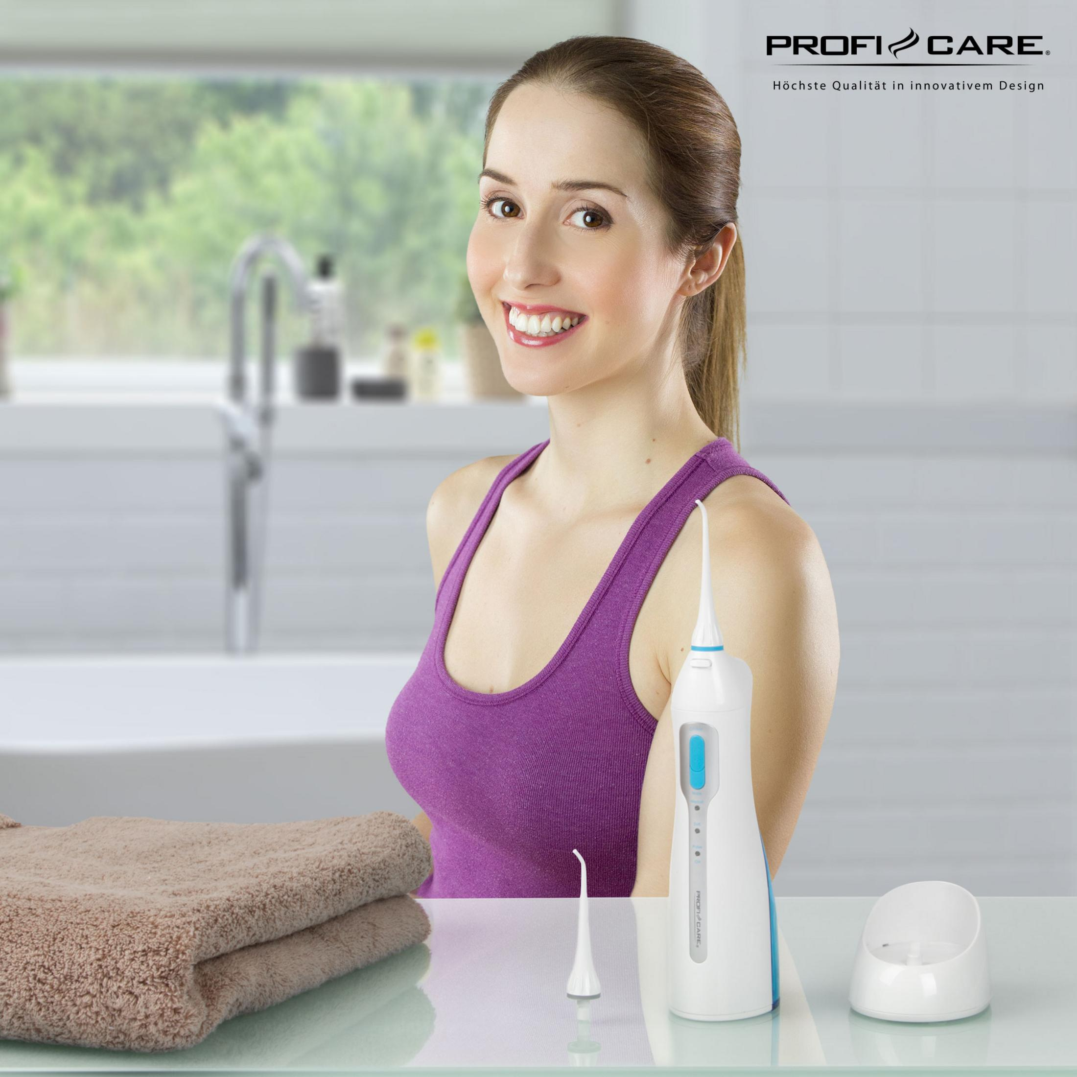 Kobieta uśmiecha się w pobliżu irygatora i ręczników.