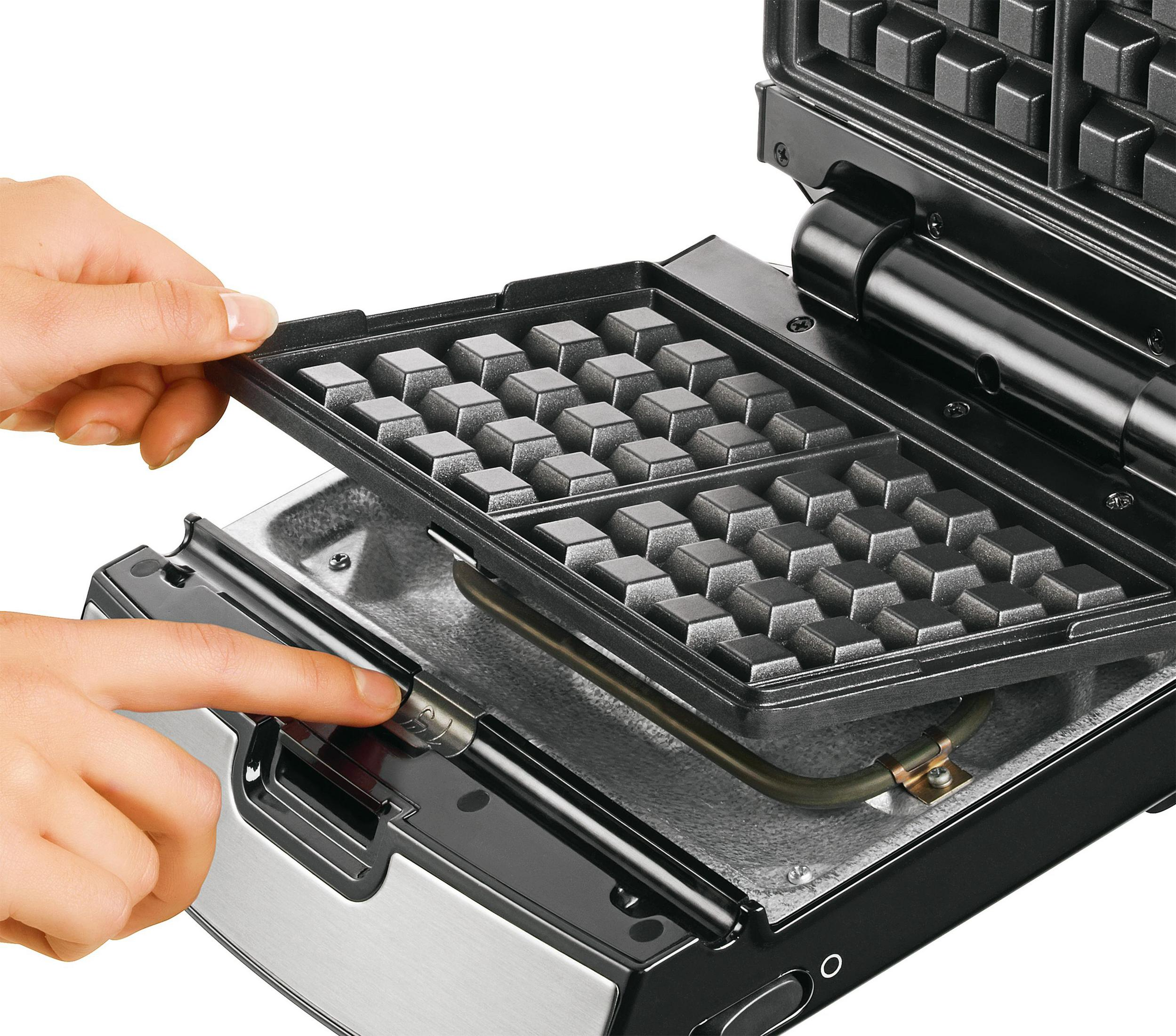 Ręce wkładające płytę do gofrownicy do gofrownicy.