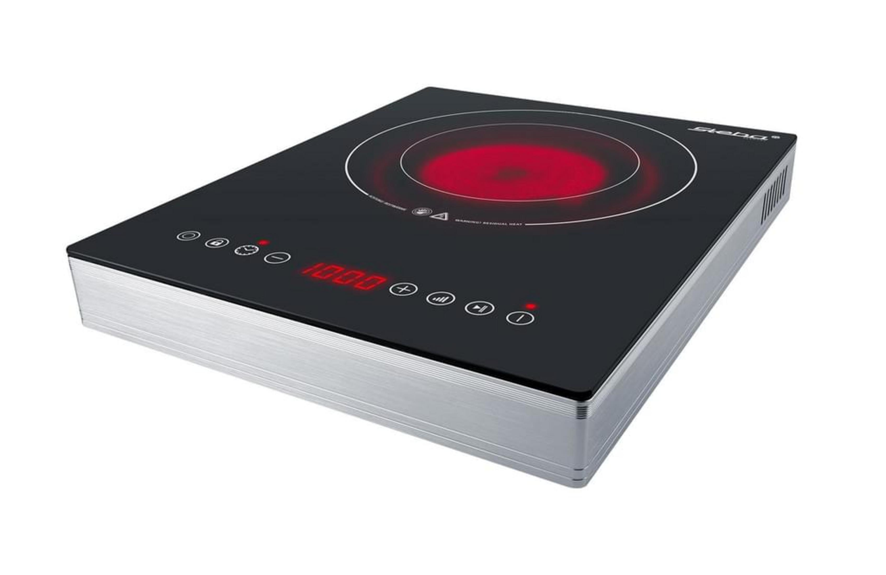 Un piano cottura a induzione nero e argento. C'è un cerchio rosso al centro e diversi pulsanti.