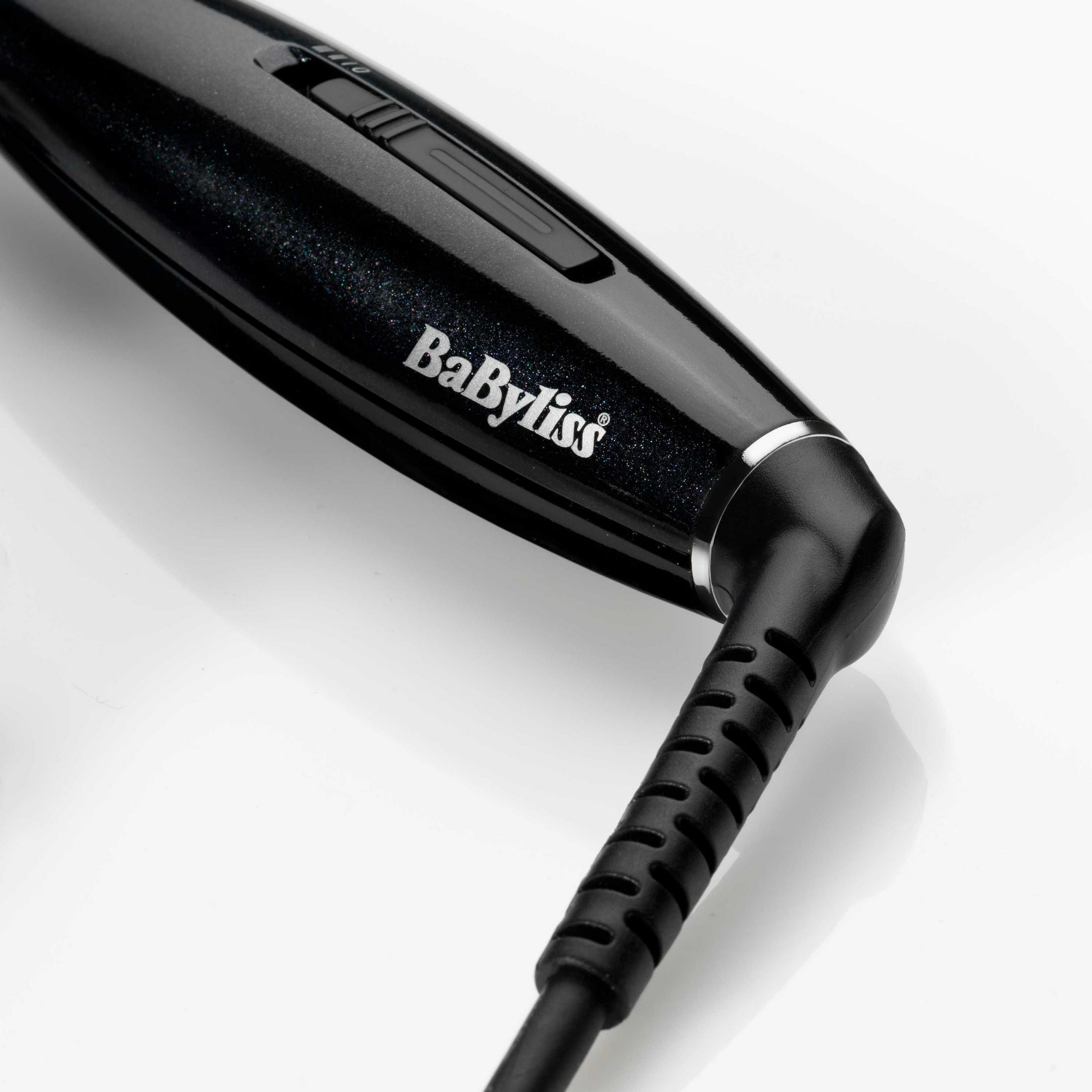Una plancha de pelo Babyliss negra con un cable conectado a su mango. El nombre de la marca es visible.