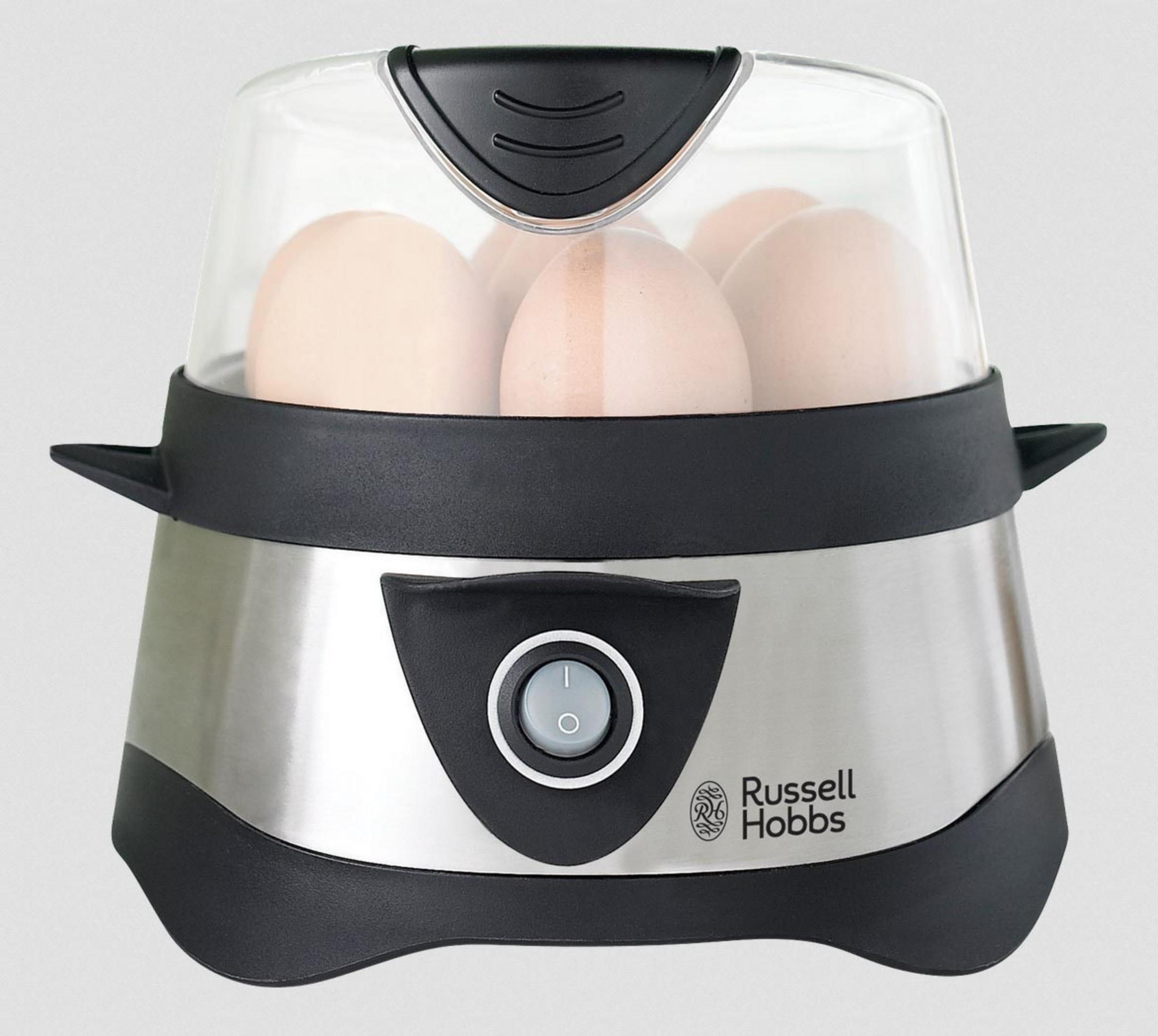 Gotowacz do jajek z jajkami w środku. To srebrne i czarne urządzenie z przezroczystą pokrywką.