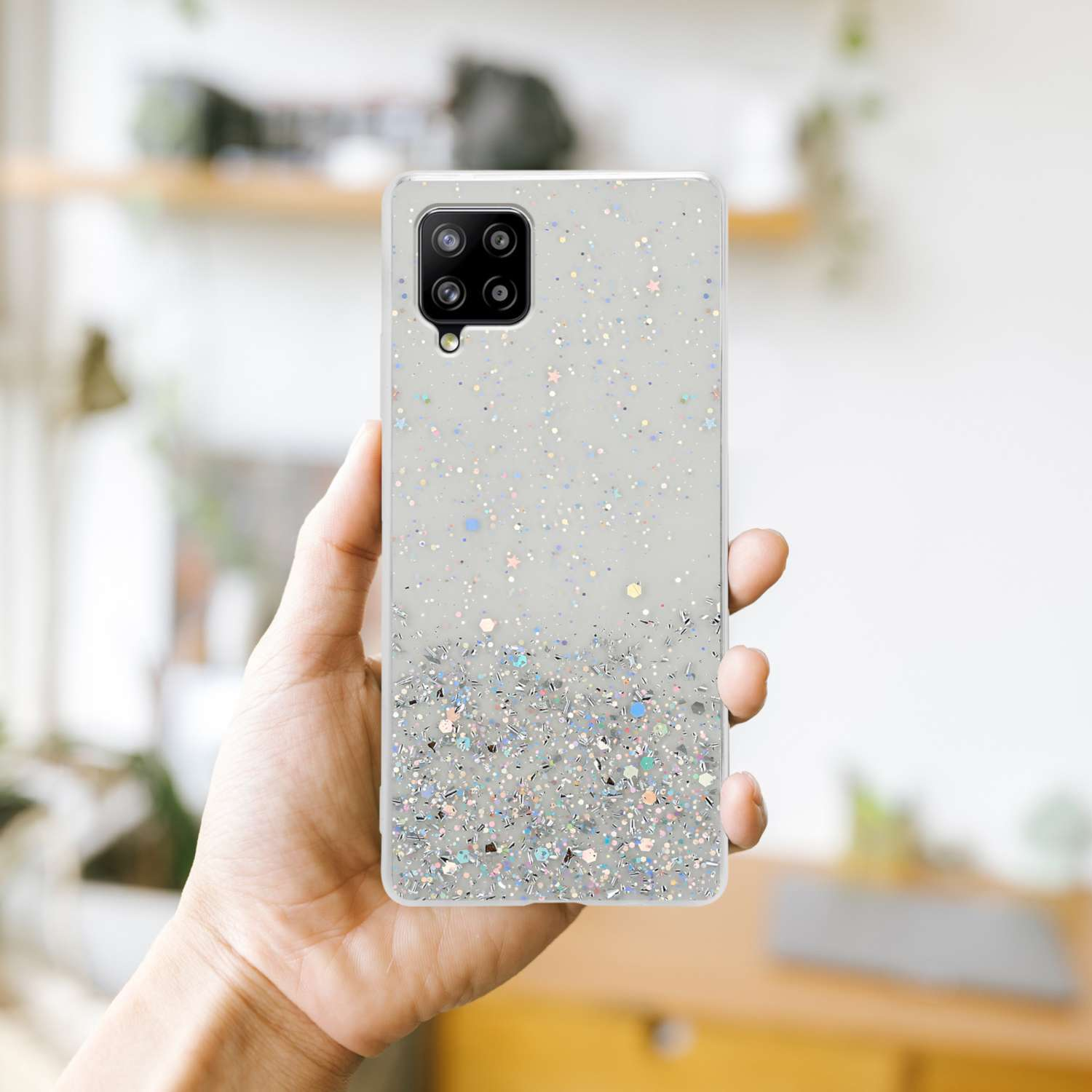 Una mano che tiene una custodia per telefono con glitter.