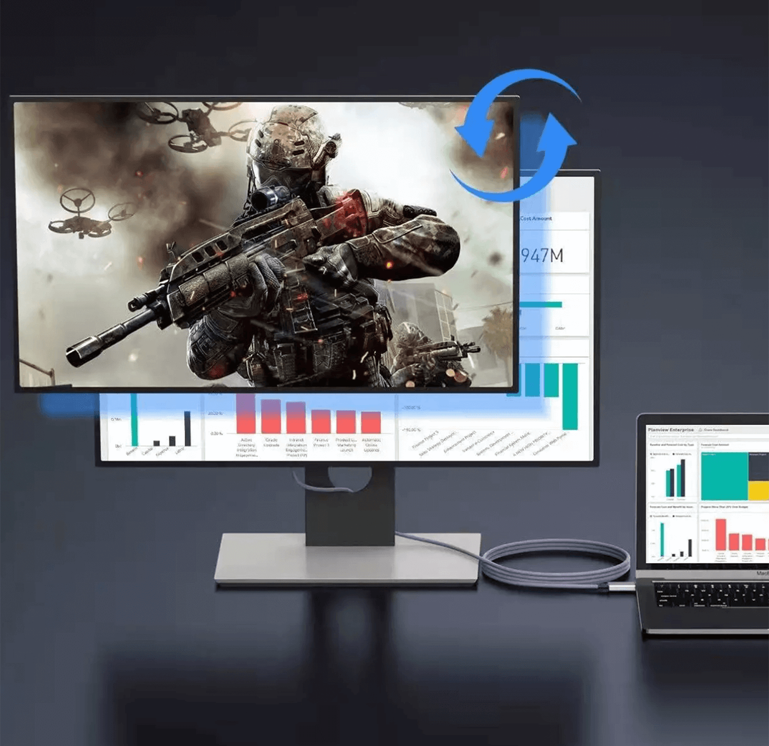 Monitor komputera wyświetla scenę bitwy. Laptop po prawej stronie pokazuje wykres.