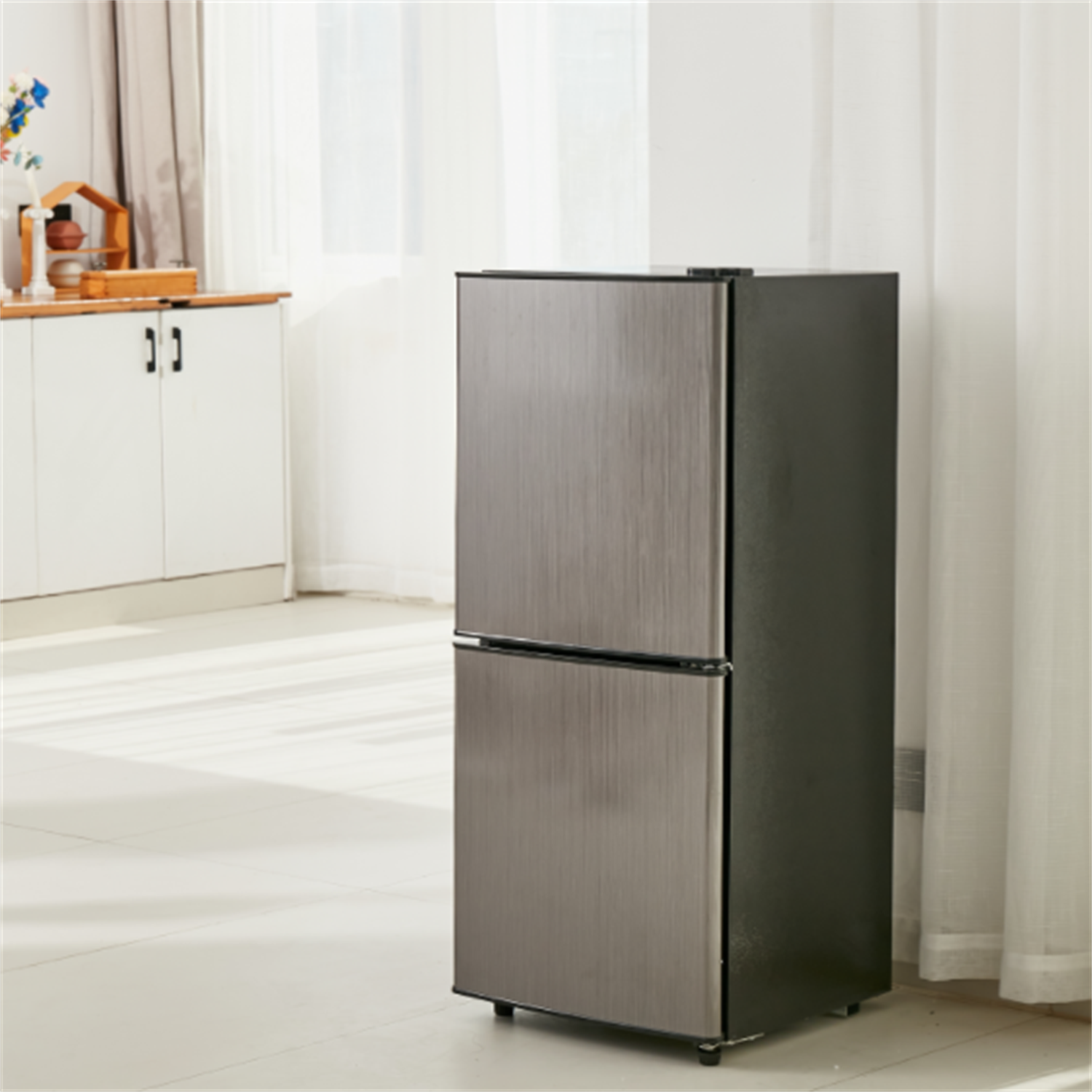 Ein Kühlschrank aus Edelstahl steht in einer hellen Küche. Der Kühlschrank hat zwei Türen.
