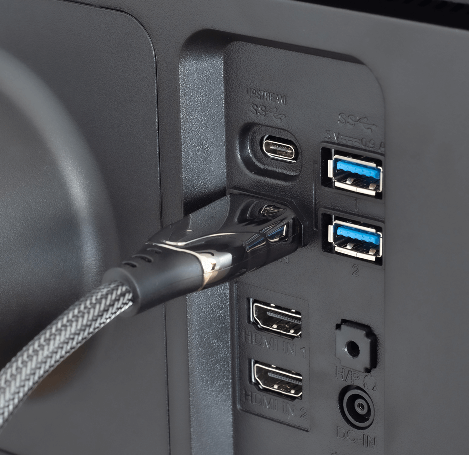 Czarny tył monitora z portami USB i HDMI oraz podłączonym kablem.