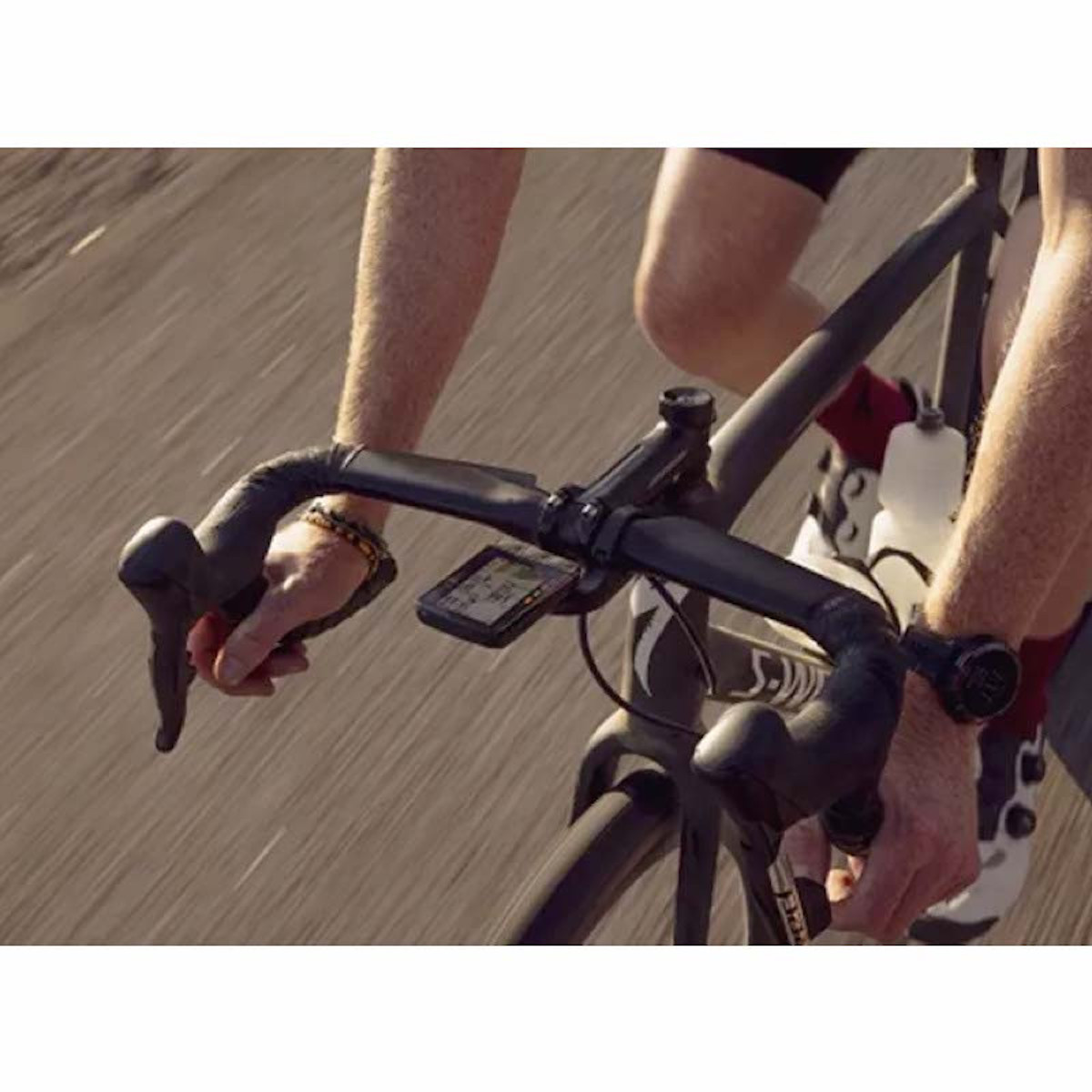 Radfahrer auf einem Fahrrad. Die Hände des Radfahrers sind am Lenker. Ein schwarzer Computer befindet sich am Lenker.