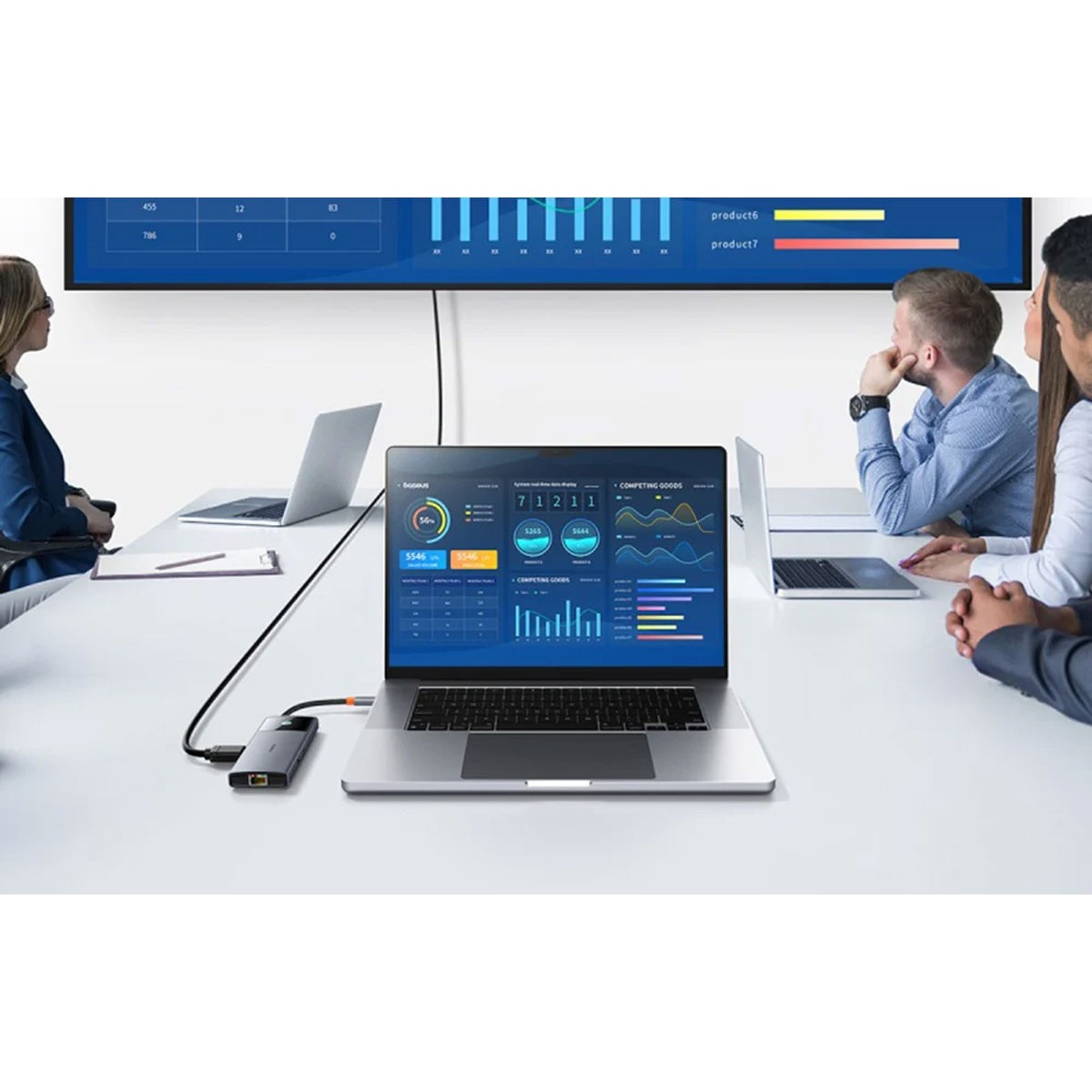 Ein Geschäftstreffen mit einem Laptop, der mit einem großen Bildschirm verbunden ist, auf dem Datendiagramme angezeigt werden.