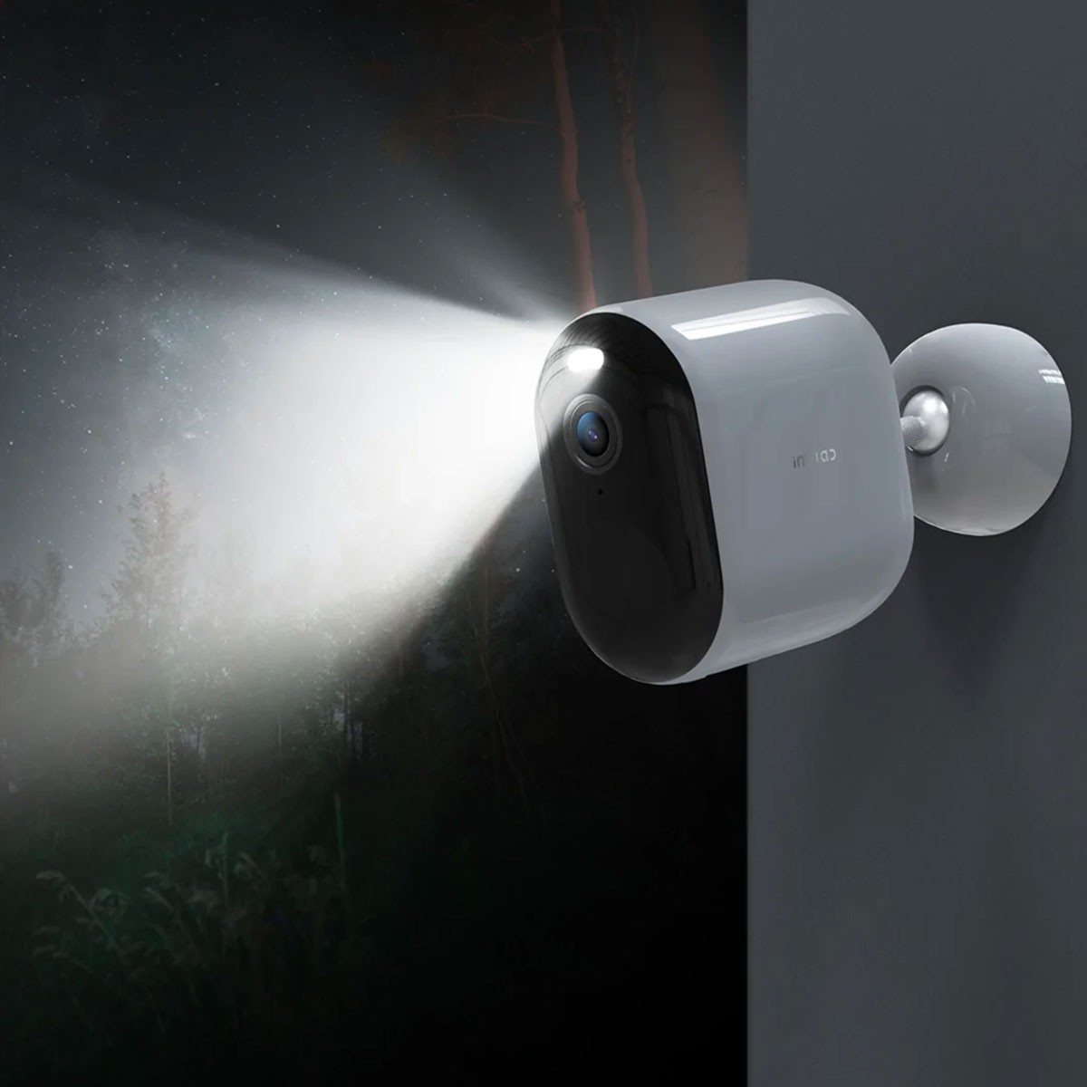 Biało-czarna kamera bezpieczeństwa na ścianie. Świeci z niej jasne światło.