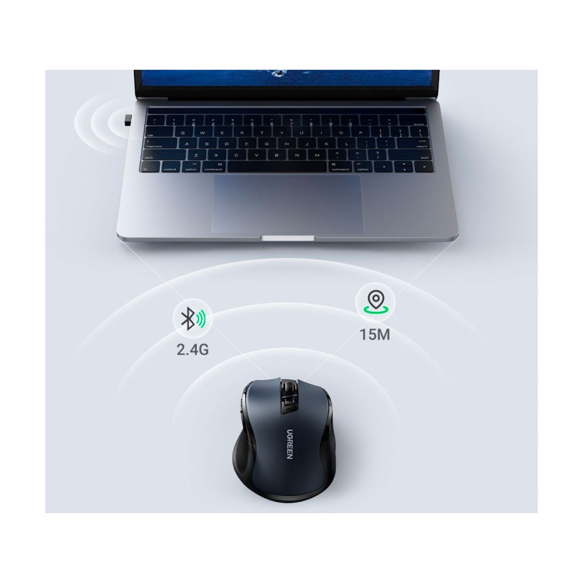Czarna mysz bezprzewodowa UGREEN obok laptopa. Symbole 2.4G i zasięg 15M.