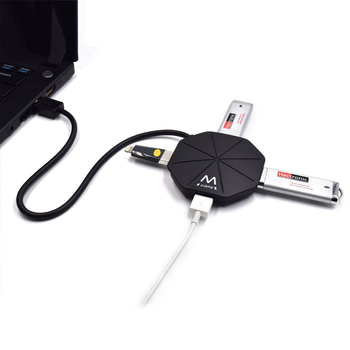 Un hub USB nero con quattro porte USB, collegato a un laptop, con unità flash inserite.