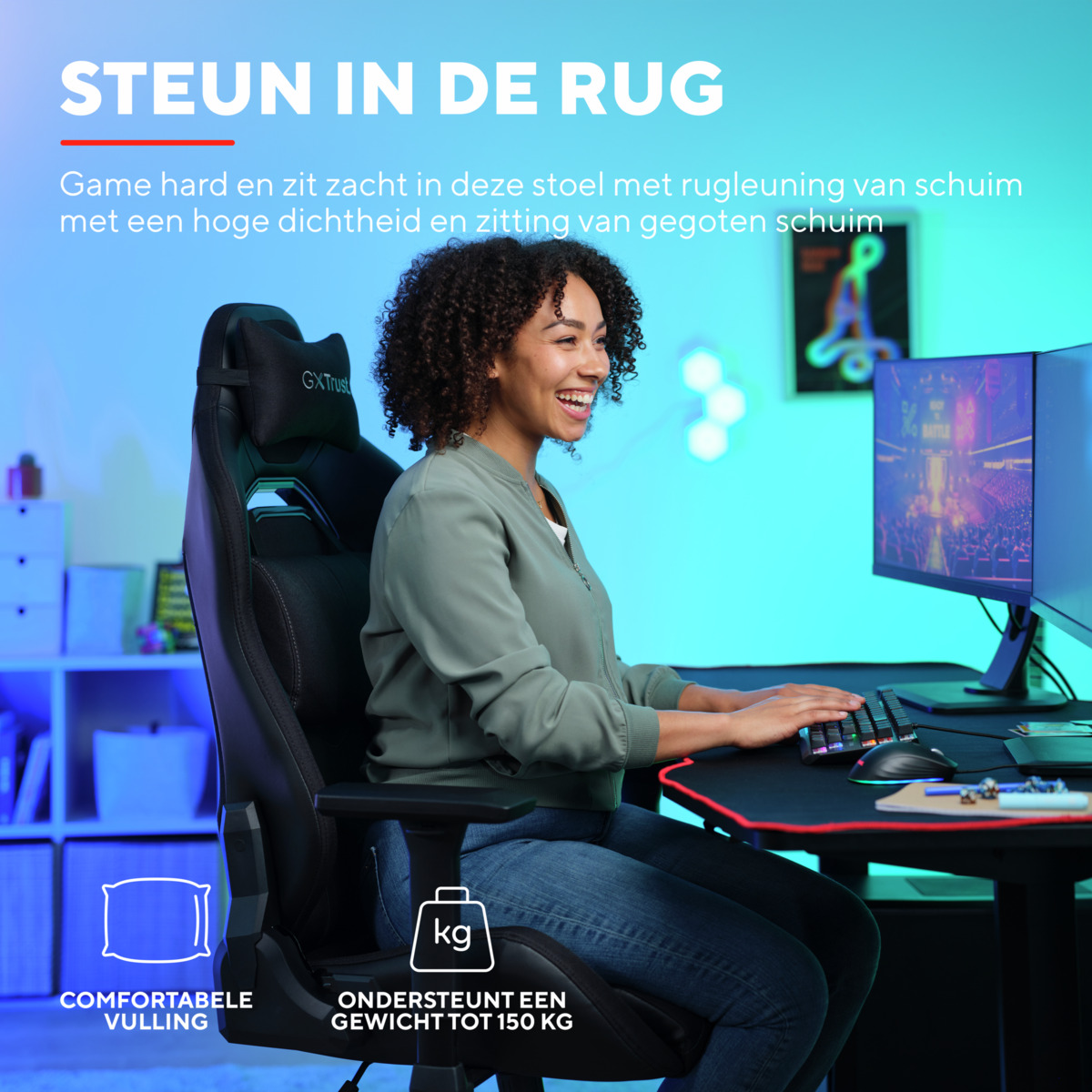 Eine Frau sitzt in einem Gaming-Stuhl und lächelt. Sie benutzt einen Computer mit Monitor und Tastatur.