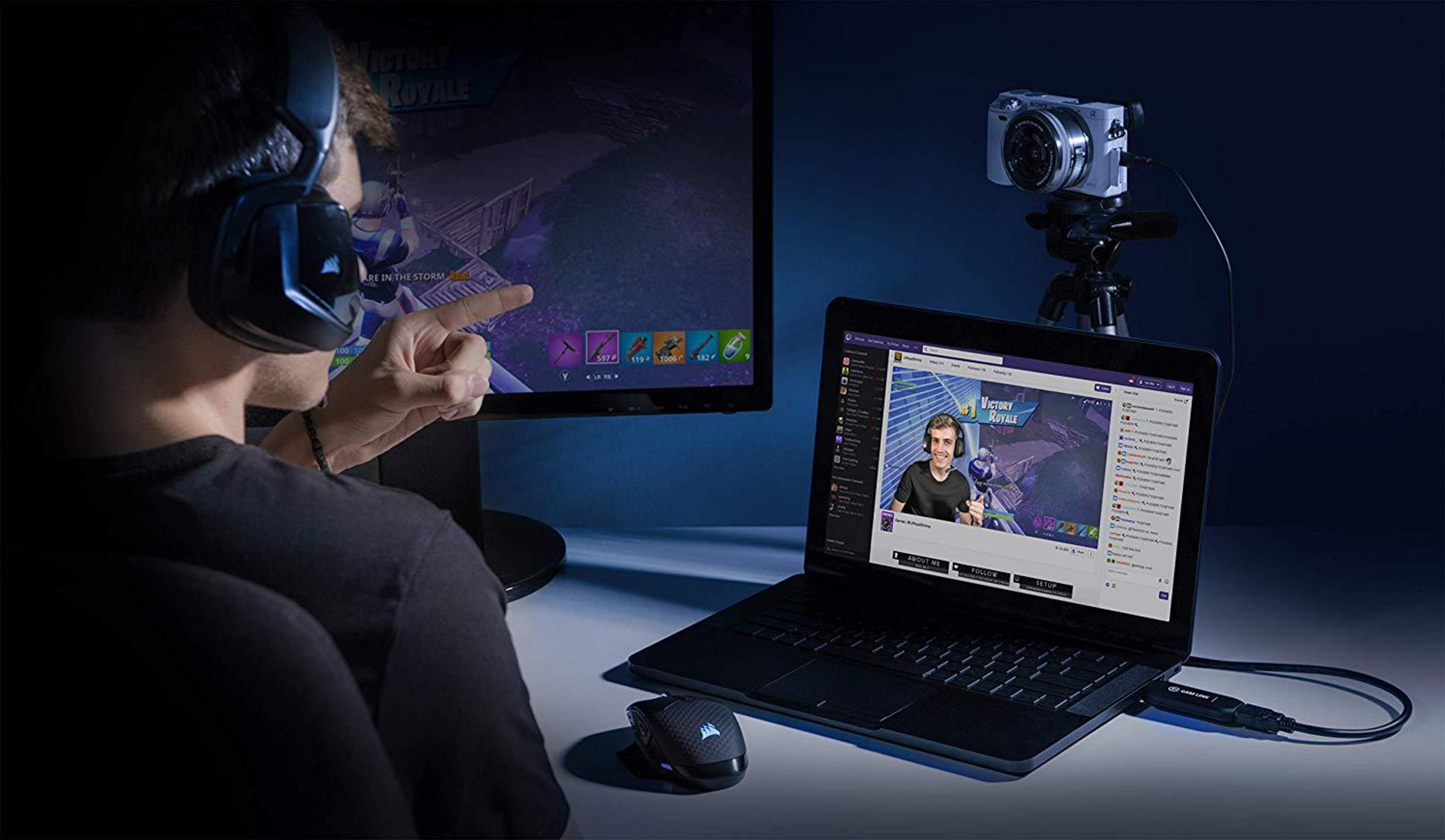 Osoba transmitująca na laptopie z kamerą i dodatkowym monitorem.