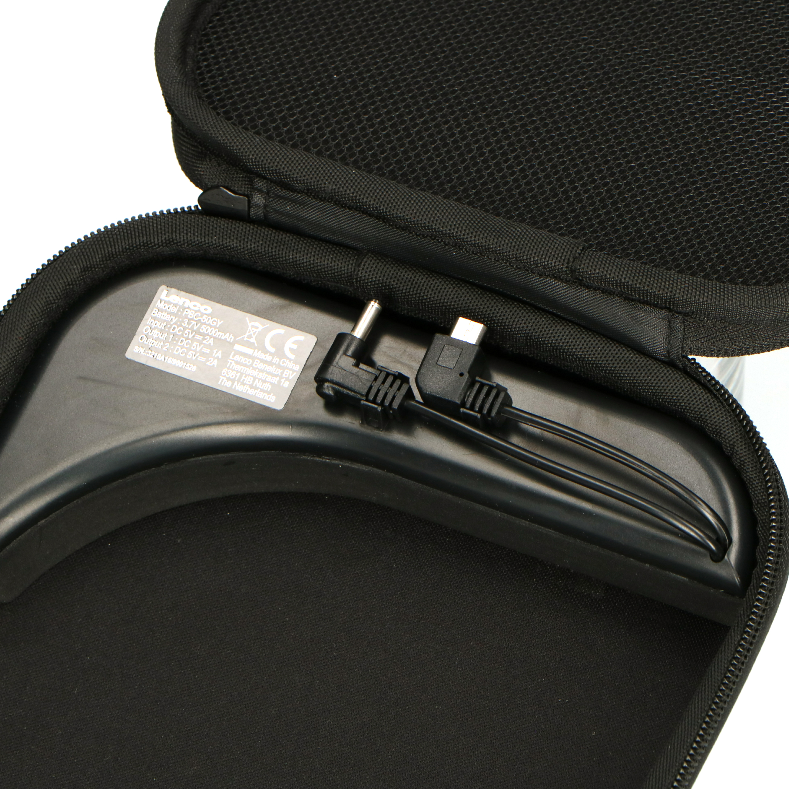 Schwarze Hülle geöffnet, mit Ladegerät und USB-Kabel. Schwarz-weißes Etikett.