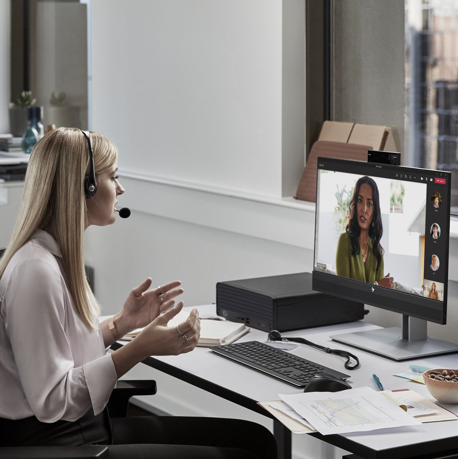 Eine Frau mit Headset in einem Videoanruf auf einem Desktop-Computer.