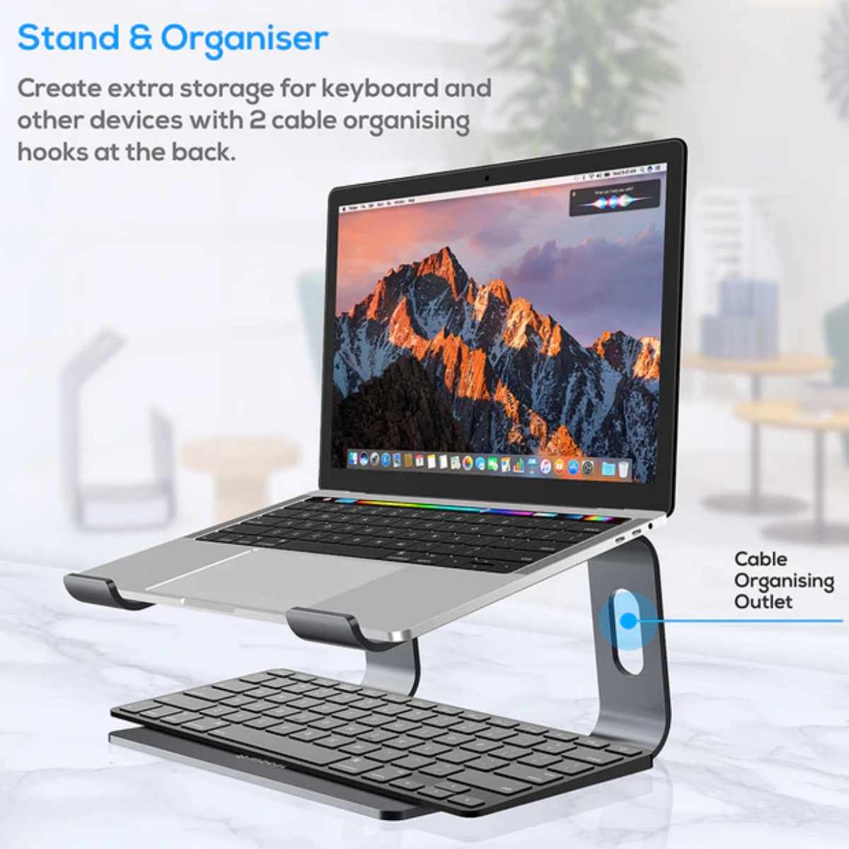 Ein Laptop auf einem silbernen Ständer mit Tastatur, auf einer Marmoroberfläche. Der Hintergrund ist unscharf.