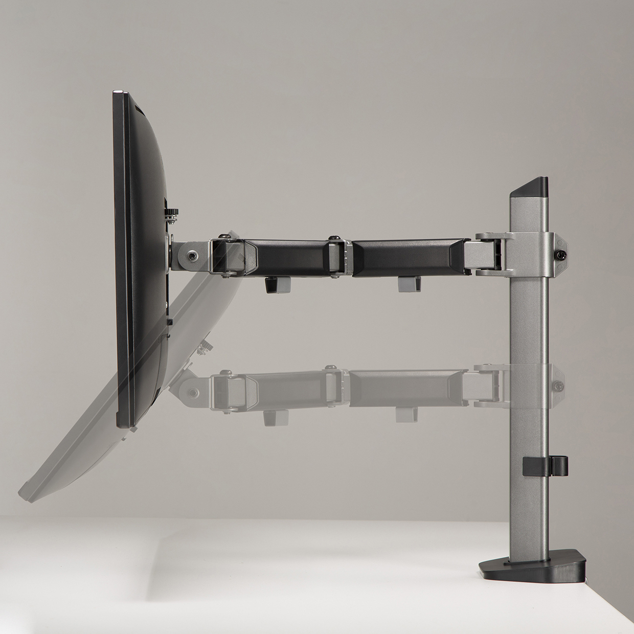 Monitor und Monitorarm auf einer weißen Oberfläche. Grauer Arm stützt den Bildschirm.