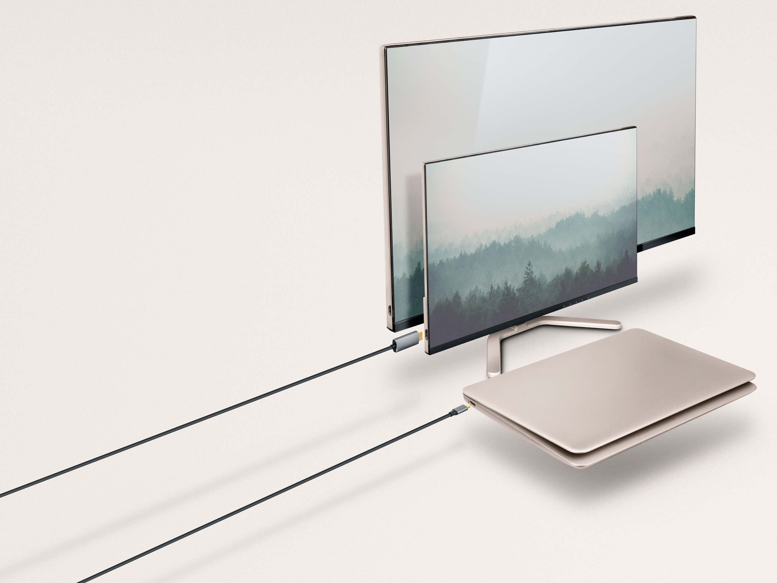 Dos monitores y una computadora portátil conectados por cables contra un fondo blanco.