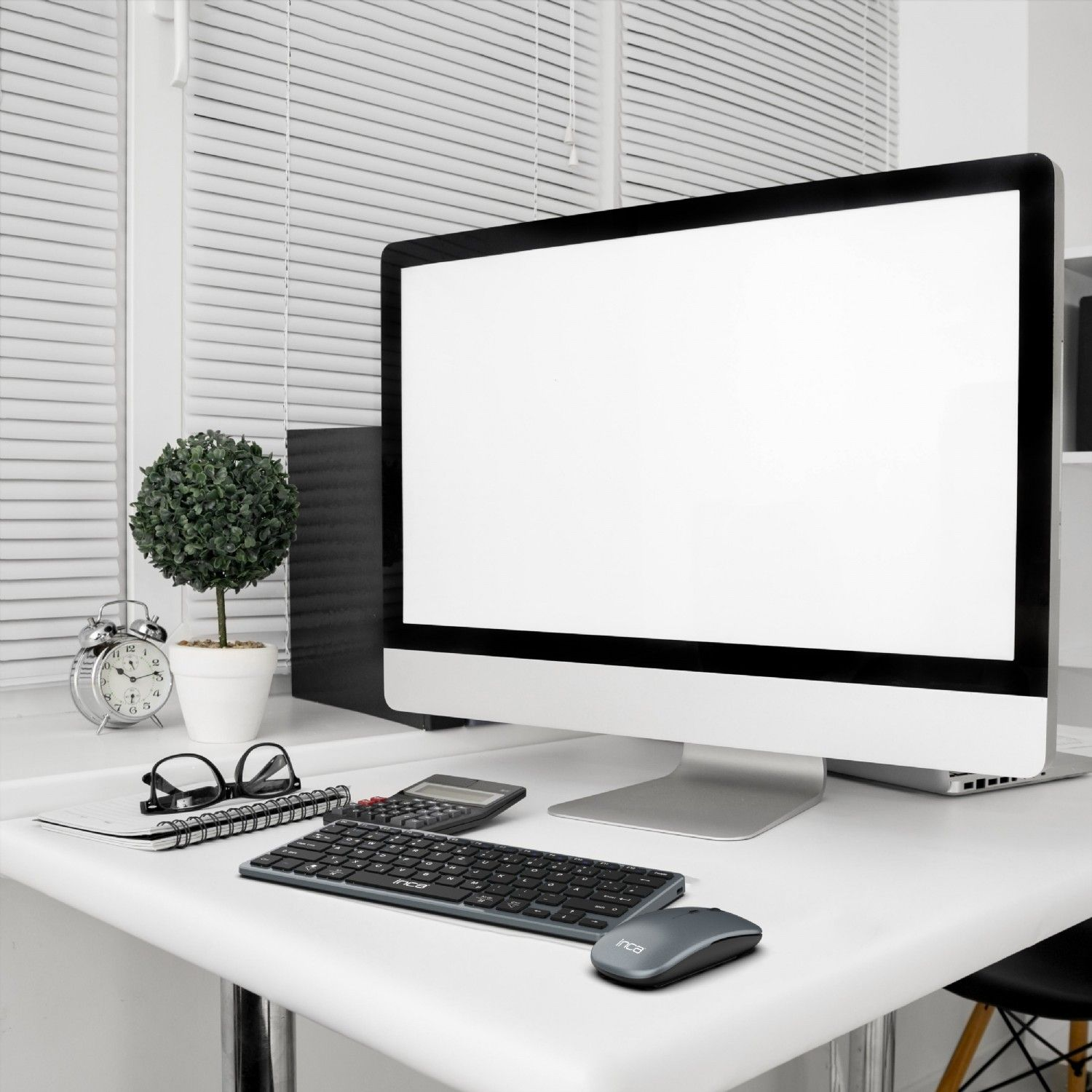 Weißer Schreibtisch mit Computer, Tastatur, Maus und Bürobedarf.