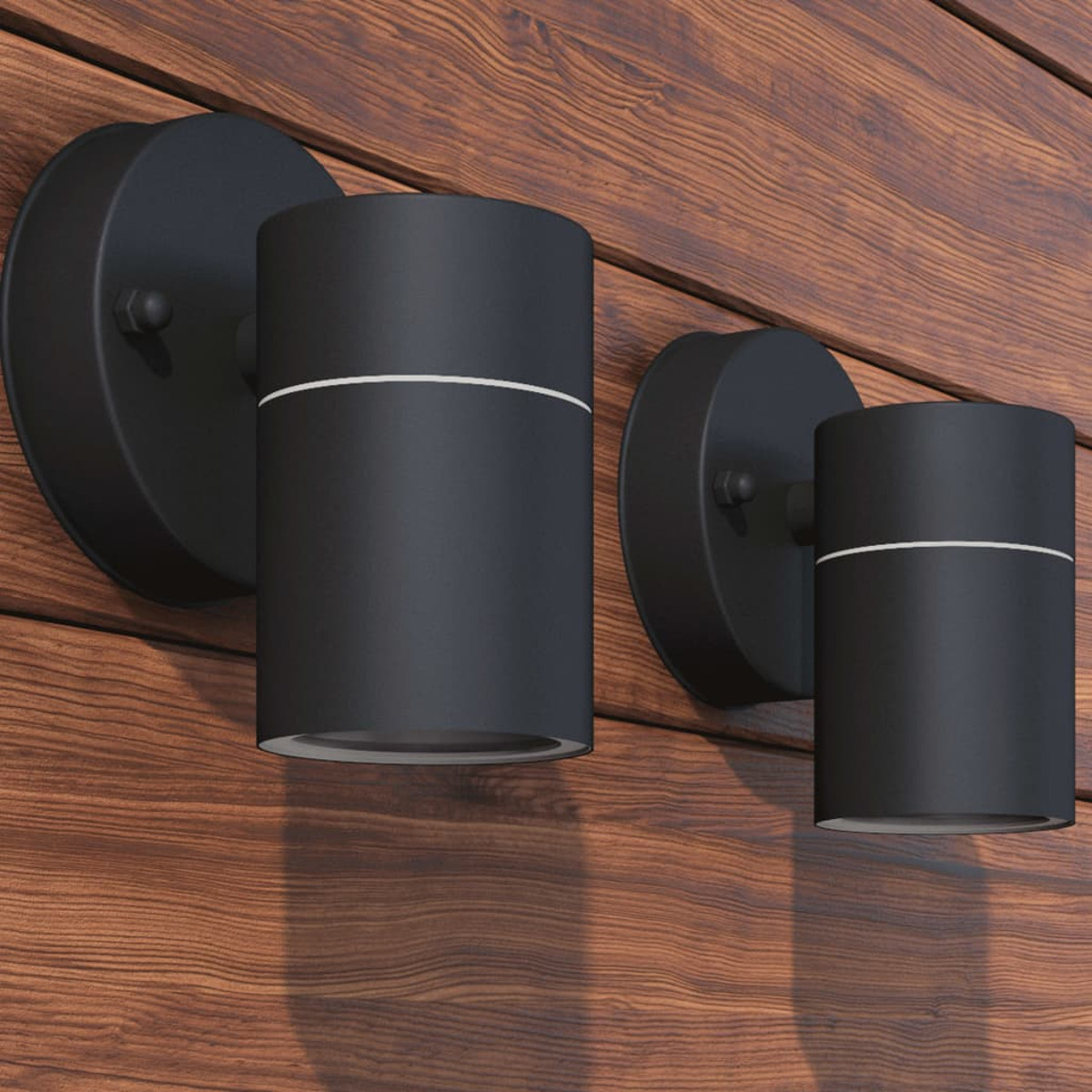 Zwei schwarze zylindrische Wandlampen an einer Holzwand, mit weißem Liniendetail oben.