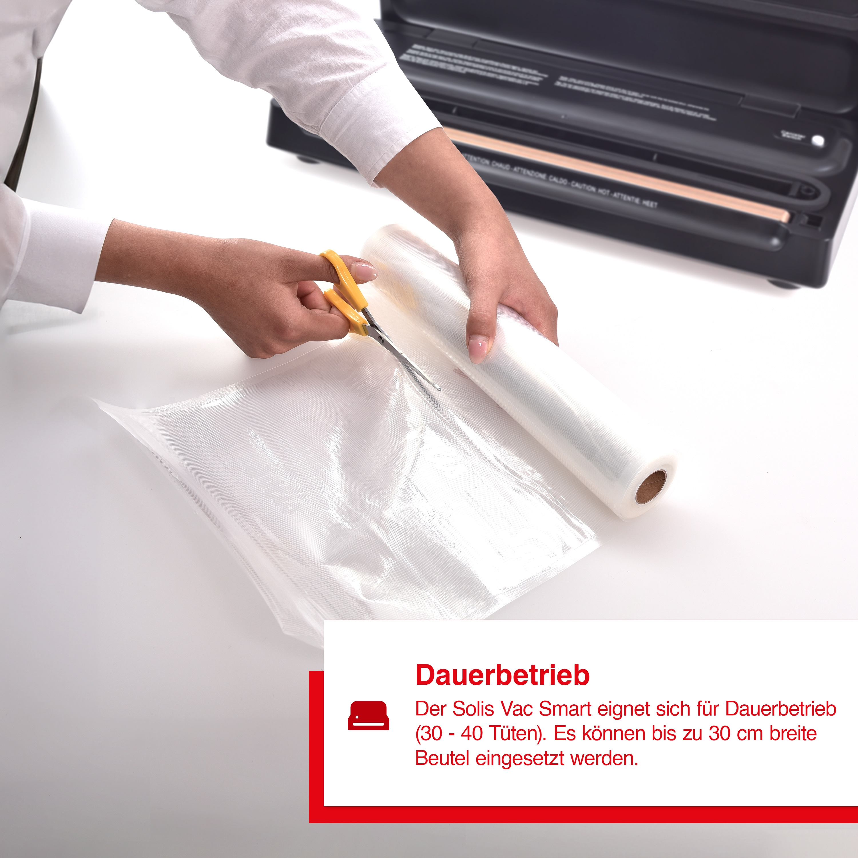 Eine Person schneidet eine Kunststoff-Vakuumba-be mit einer Schere neben einer Rolle ähnlicher Beutel.