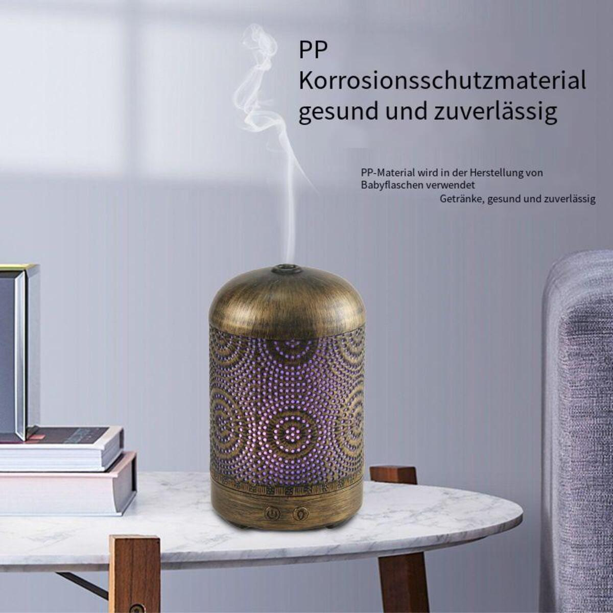 Öldiffusor mit dekorativem Muster und aufsteigendem Dampf, auf einem Tisch platziert.
