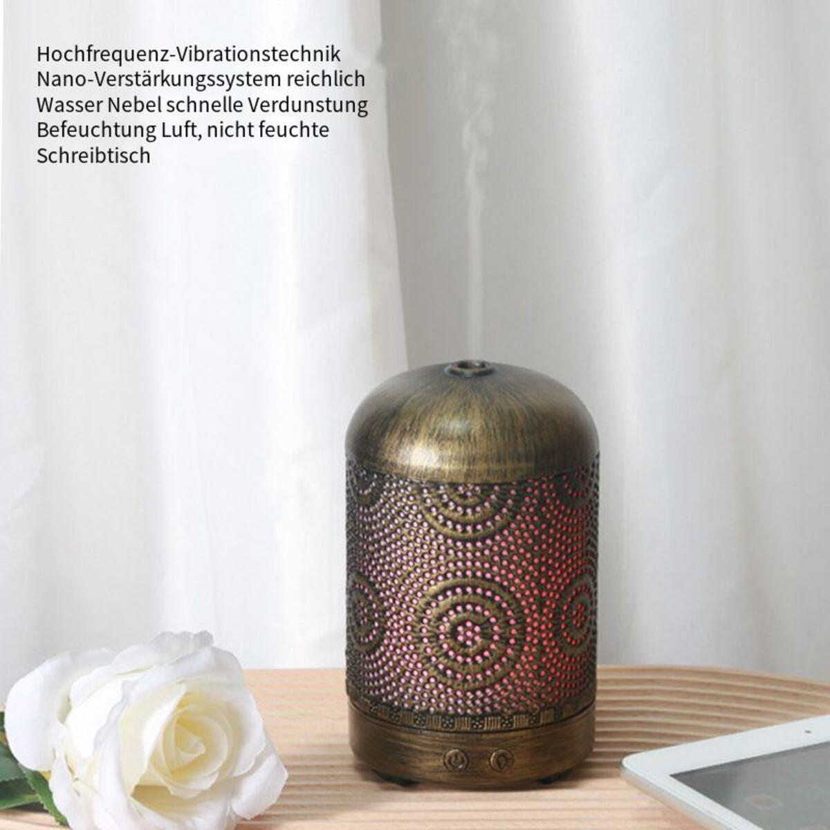 Öldiffusor mit Text auf einem Tisch und einer weißen Rose.
