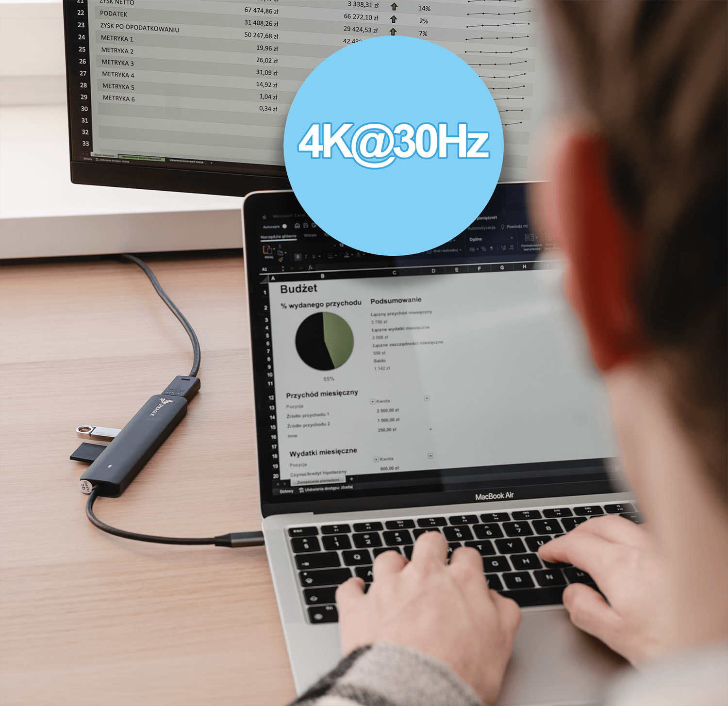 Osoba korzystająca z laptopa podłączonego do monitora. Niebieskie pole tekstowe mówi 4K@30Hz.