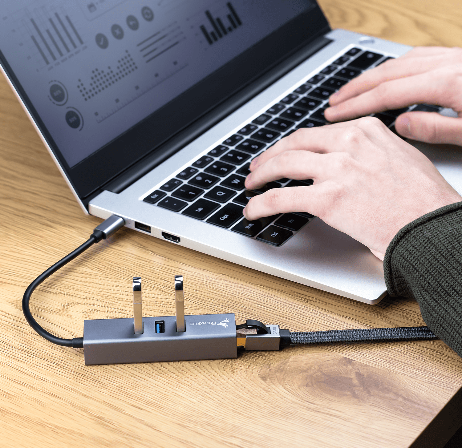 Eine Person, die einen Laptop mit einem daran angeschlossenen USB-Hub verwendet.