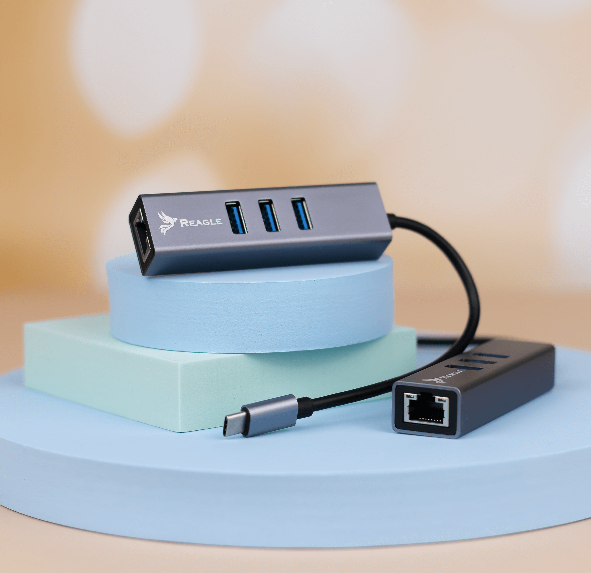 Grauer USB-Hub mit drei Anschlüssen, einem schwarzen Kabel und einem Hintergrund aus blauen und grünen Plattformen.