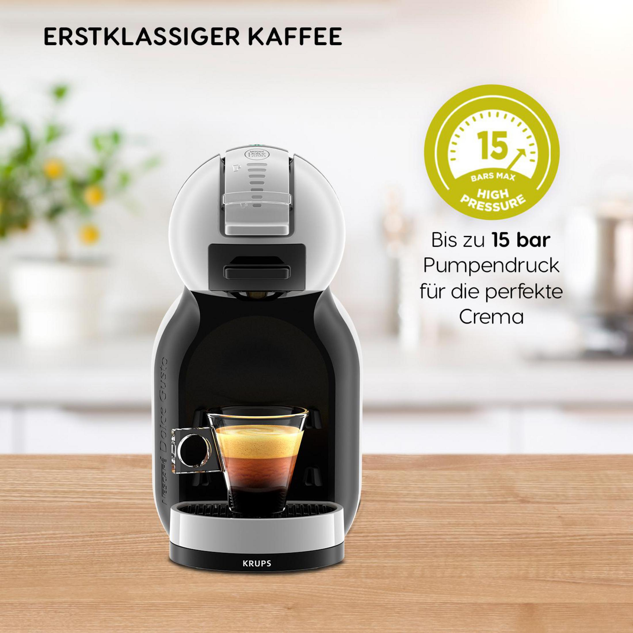 Eine schwarz-weiße Kaffeemaschine mit einem Glas geschichtetem Kaffee.