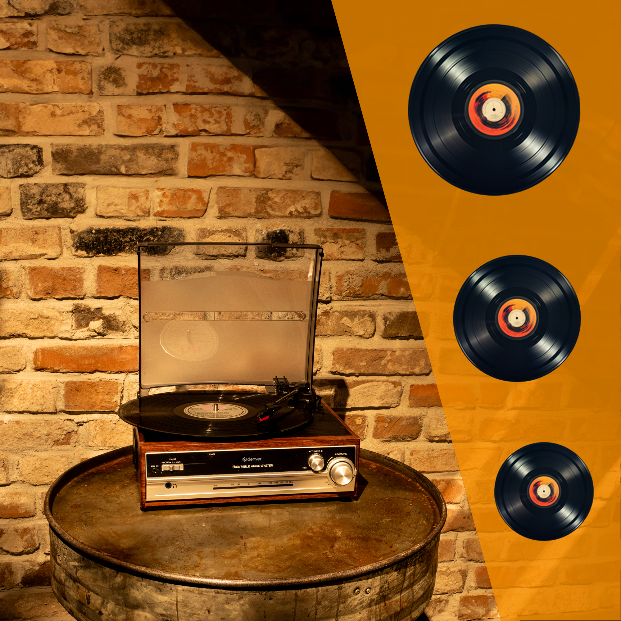 Gramofon na beczce z trzema płytami winylowymi. Tło z ceglanego muru.