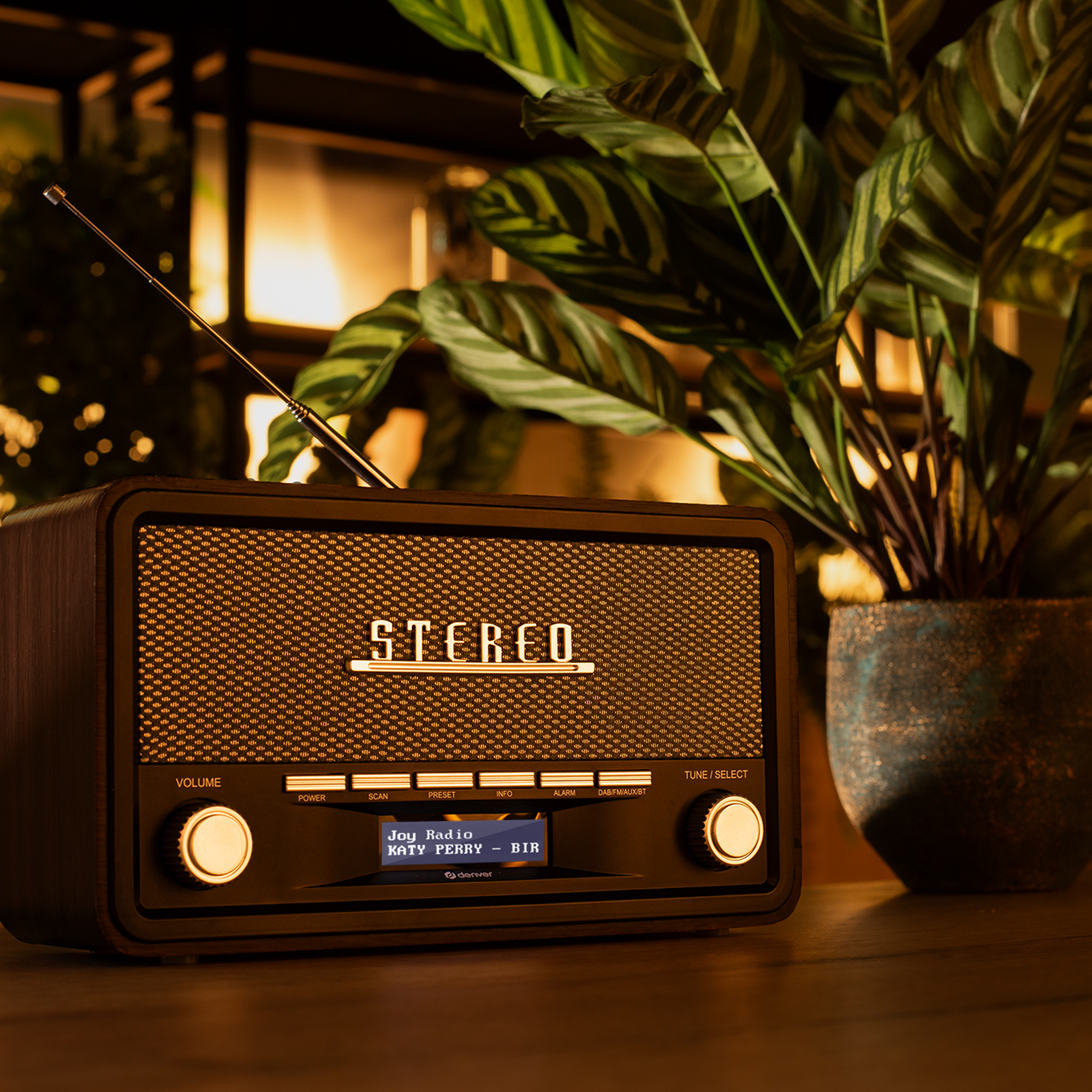 Radio w stylu vintage, drewniana obudowa, z rośliną w niebieskiej doniczce.