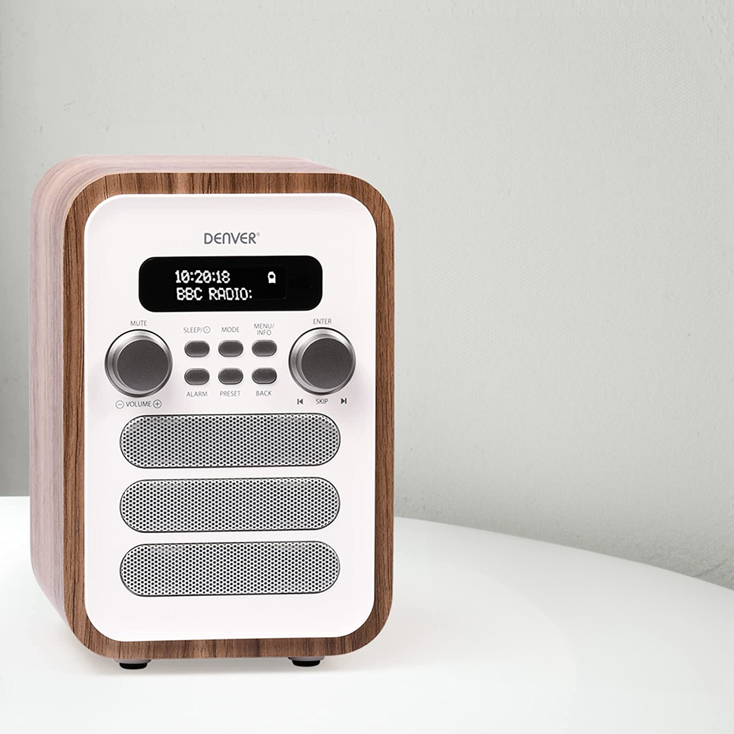 Drewniane radio z cyfrowym wyświetlaczem pokazującym godzinę i BBC Radio. Białe tło.